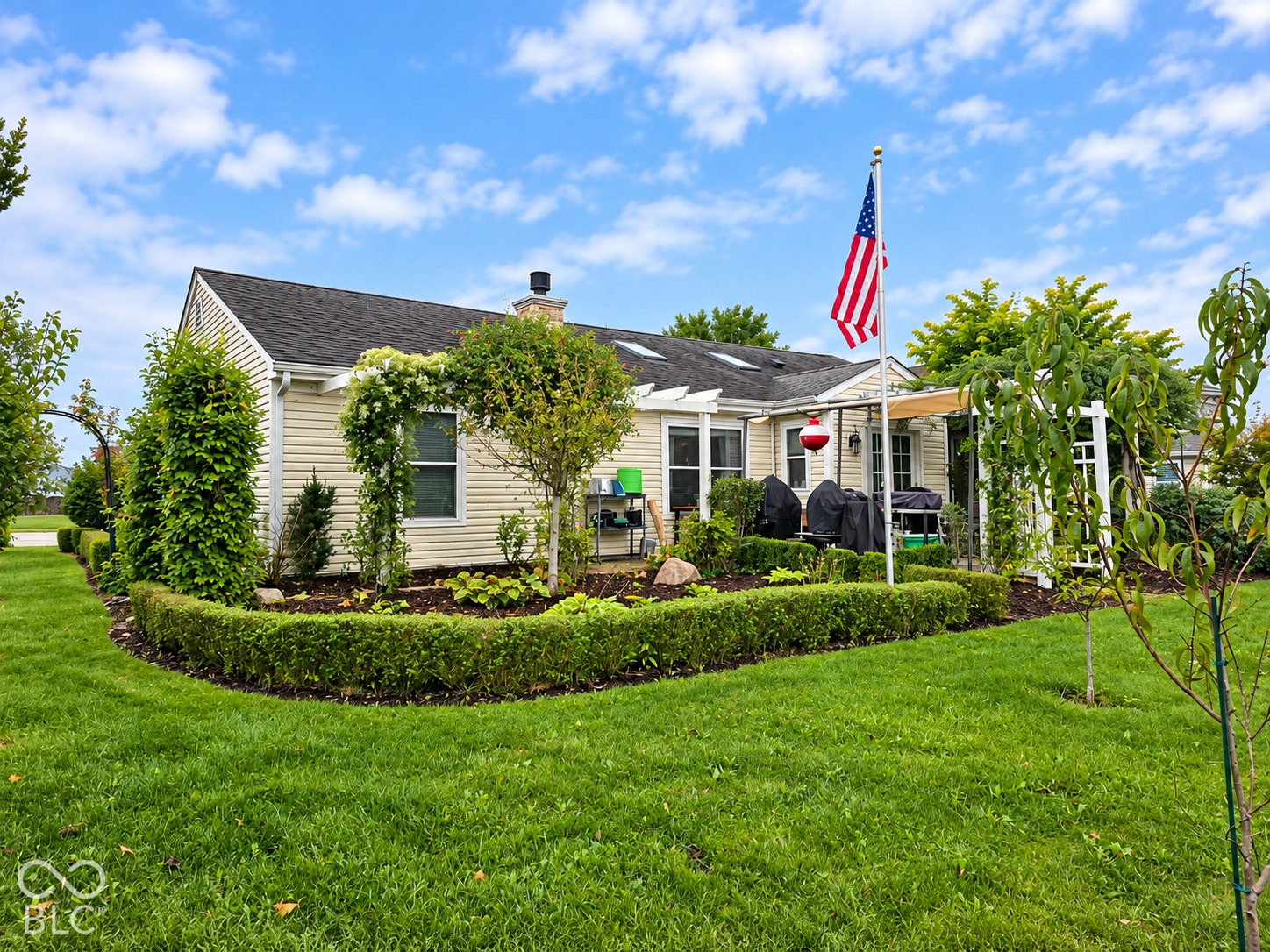 Exterior siding with a shingled roof, featuring a backyard with a manicured lawn