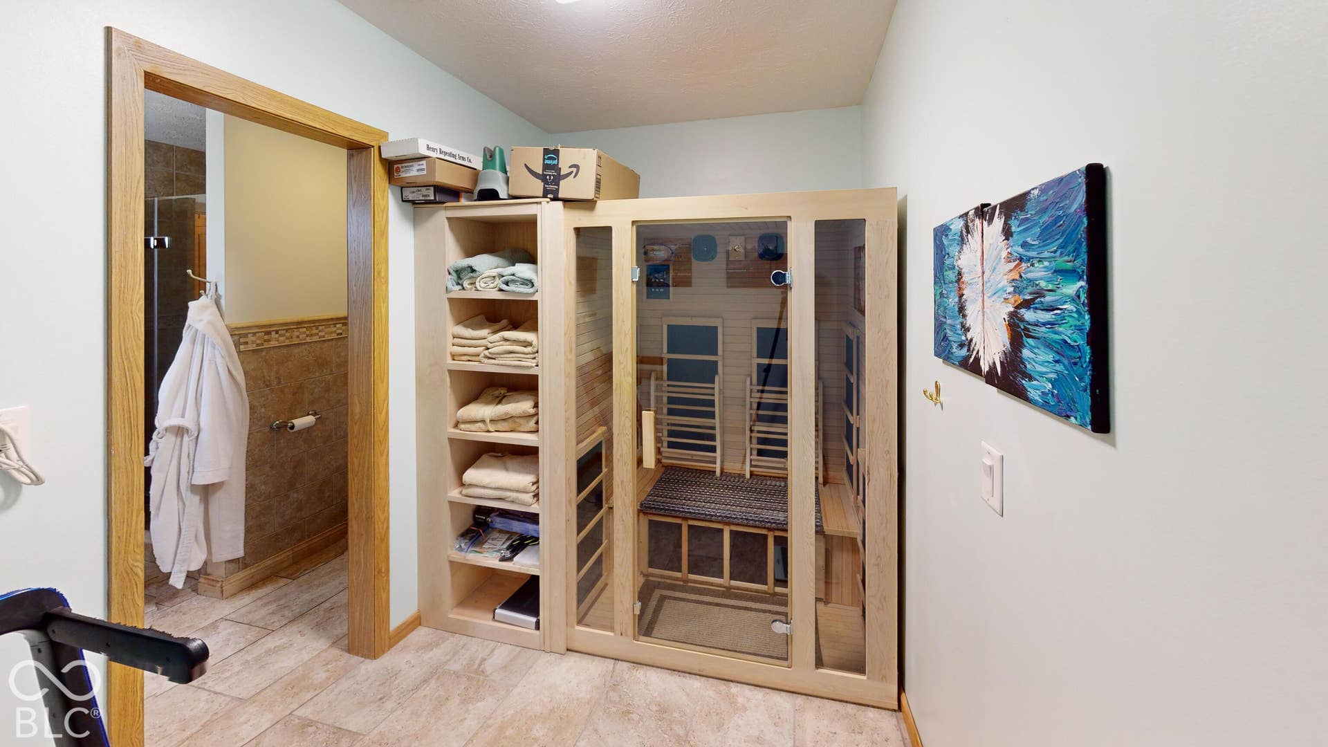 Built-in sauna with a glass door, custom shelving storage, and wood-finish flooring