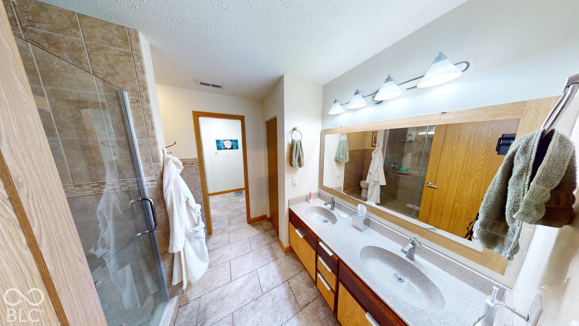 Double vanity with dual undermount sinks, a framed mirror, and integrated lighting