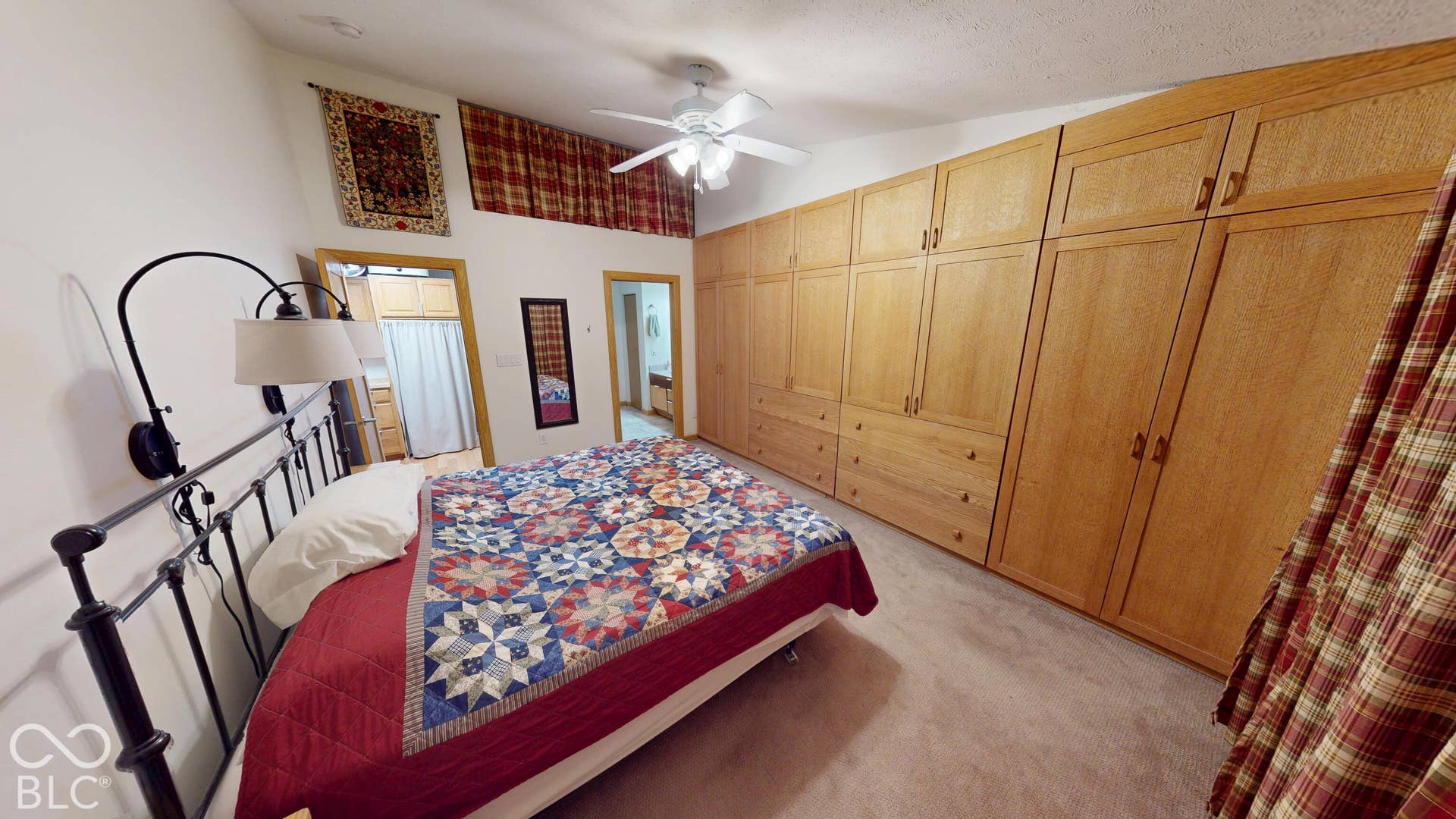 Bedroom #3 Vaulted ceiling with ceiling fan, wall-mounted light fixture, and extensive built-in cabinetry with wood-finish doors and drawers