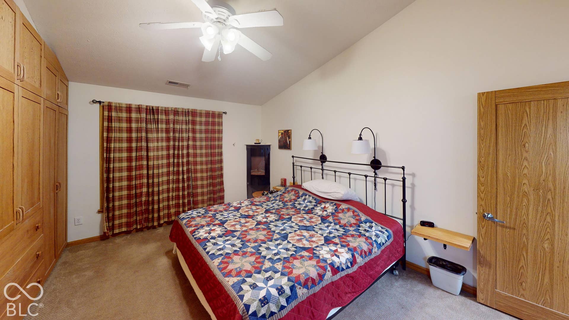 Bedroom #3 Vaulted ceiling with a ceiling fan light fixture, wood-finish built-in storage, and wall-mounted sconces