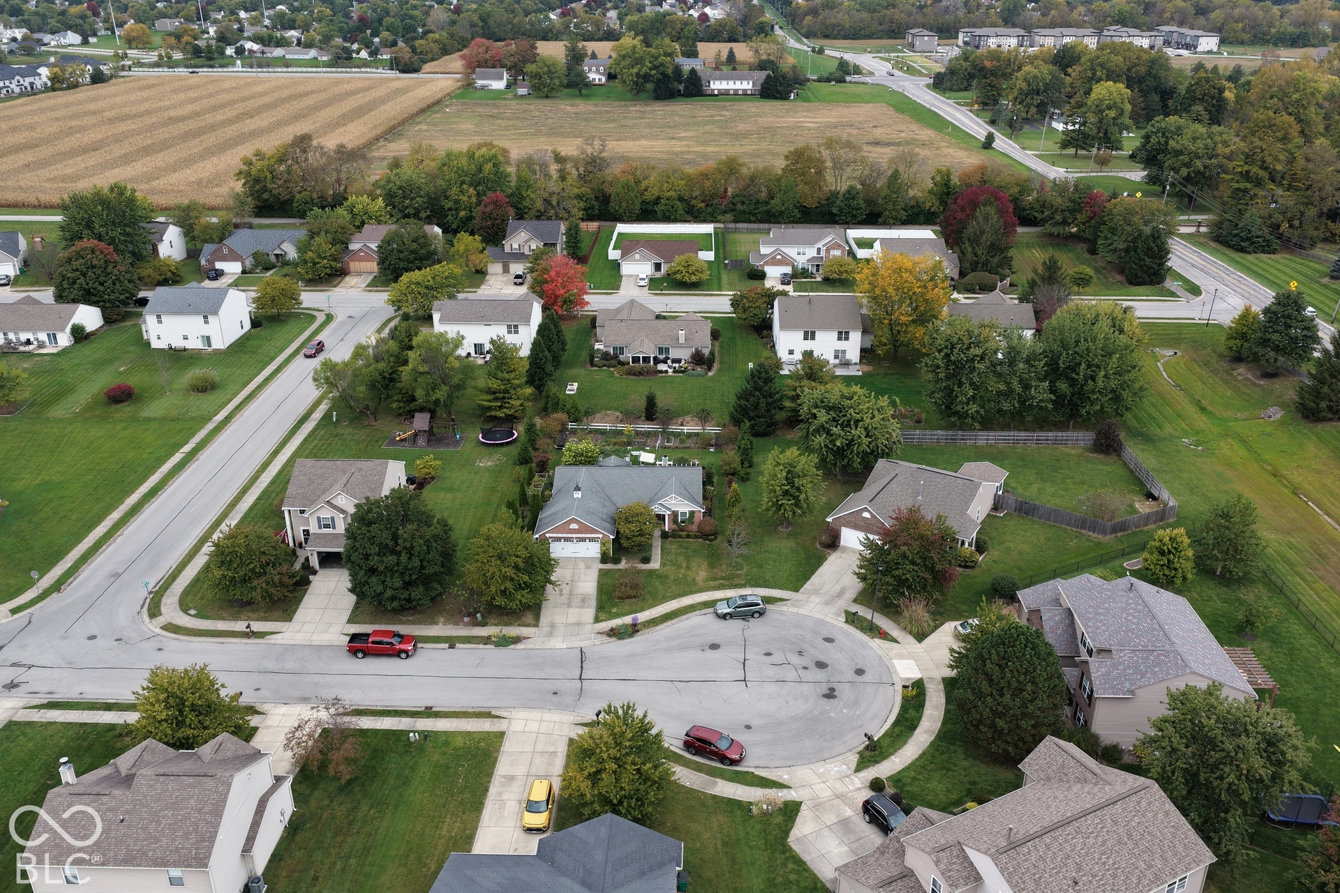 Aerial perspective of a residential cul-de-sac featuring paved streets, concrete driveways, and established landscaping