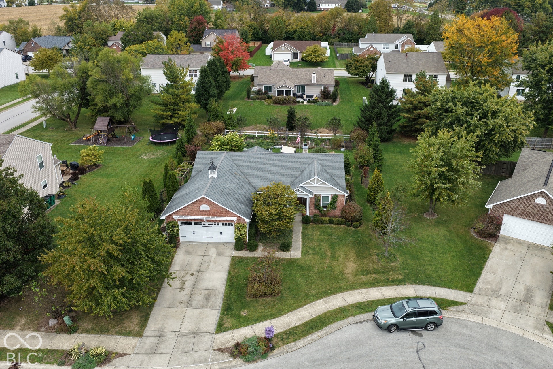 Single-story residence featuring a brick and siding exterior, an attached two-car garage, a steep-pitched roof with a decorative cupola, and a concrete driveway