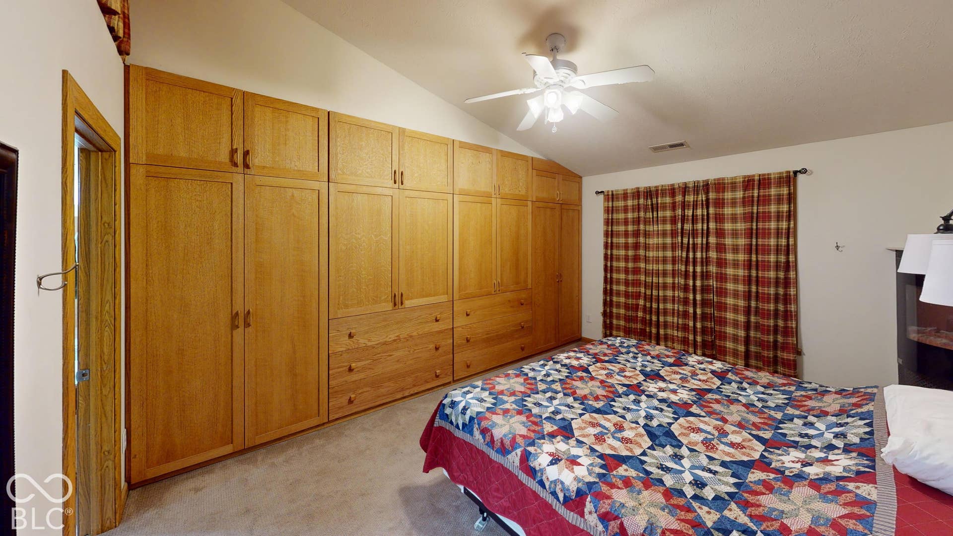 Bedroom #3 =Angled ceiling with a ceiling fan and a full wall of closet/dresser space built into the wall.