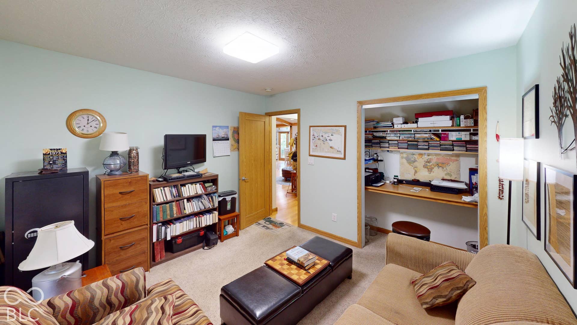 Bedroom # 1 - Currently used as an extra living room/sitting space. But is a bedroom with a large closet. Recessed lighting and a window with wood-trim, Light-colored wall paint with carpeted flooring
