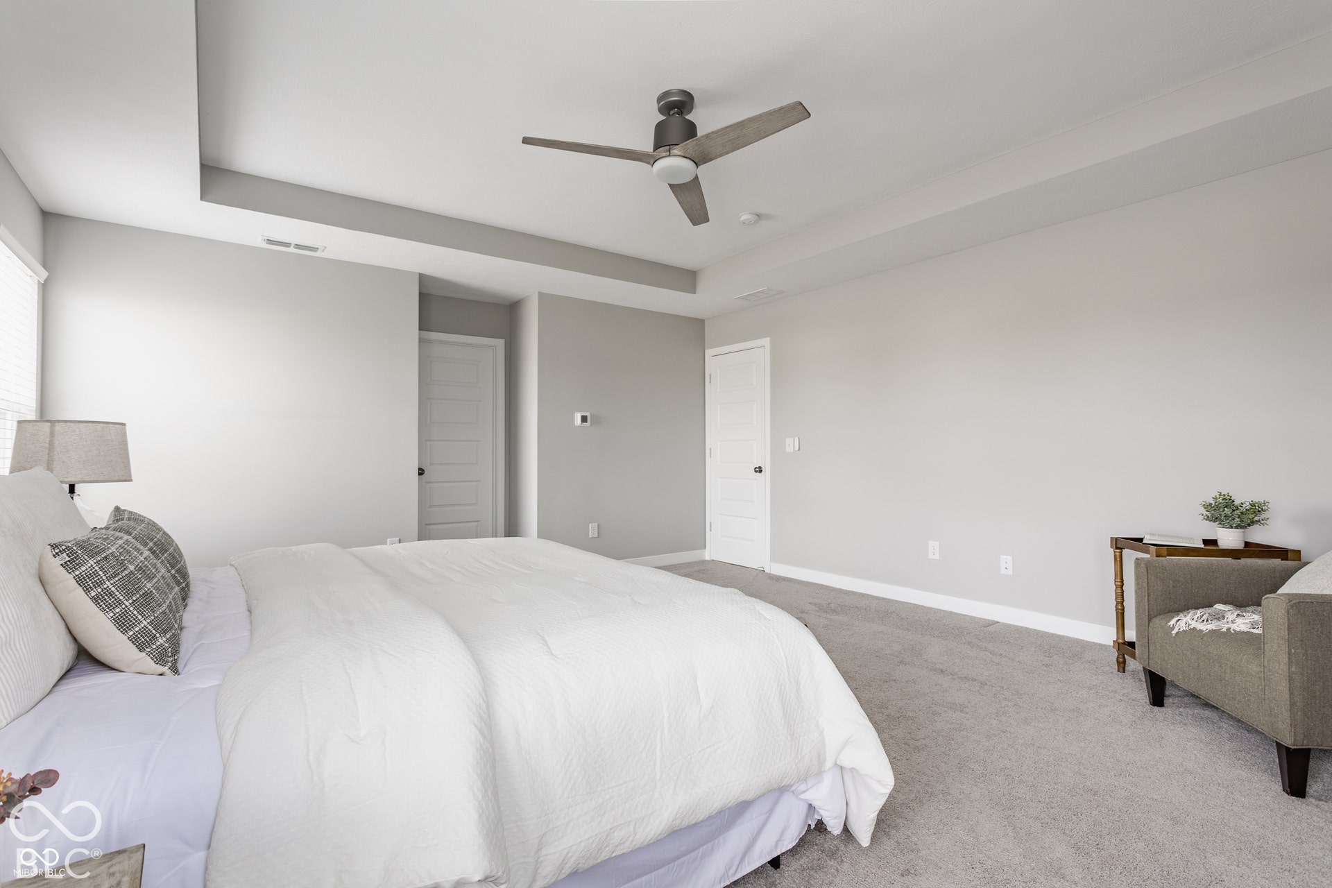 Tray ceiling with recessed lighting, neutral wall palette, plush wall-to-wall carpeting, and a modern ceiling fan