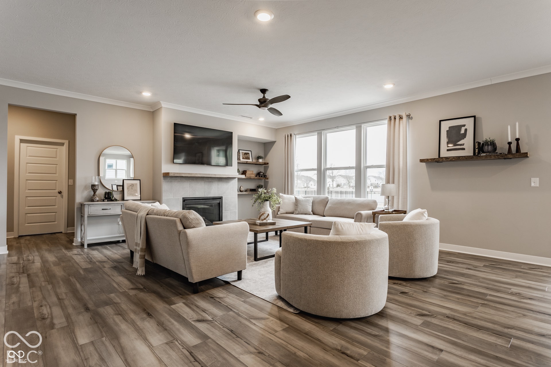 Living area featuring wood-finish flooring, recessed lighting, a ceiling fan, a gas fireplace with a stone-style surround, and built-in shelving