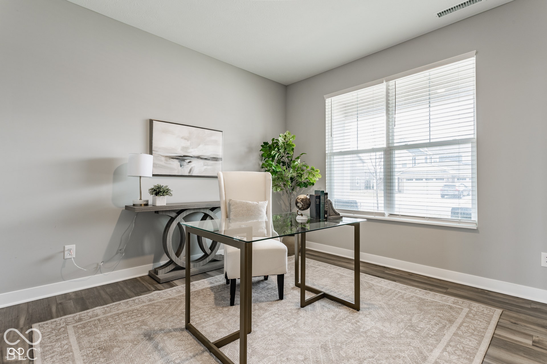 Room featuring wood-finish flooring, neutral wall paint, and a large window with horizontal blinds