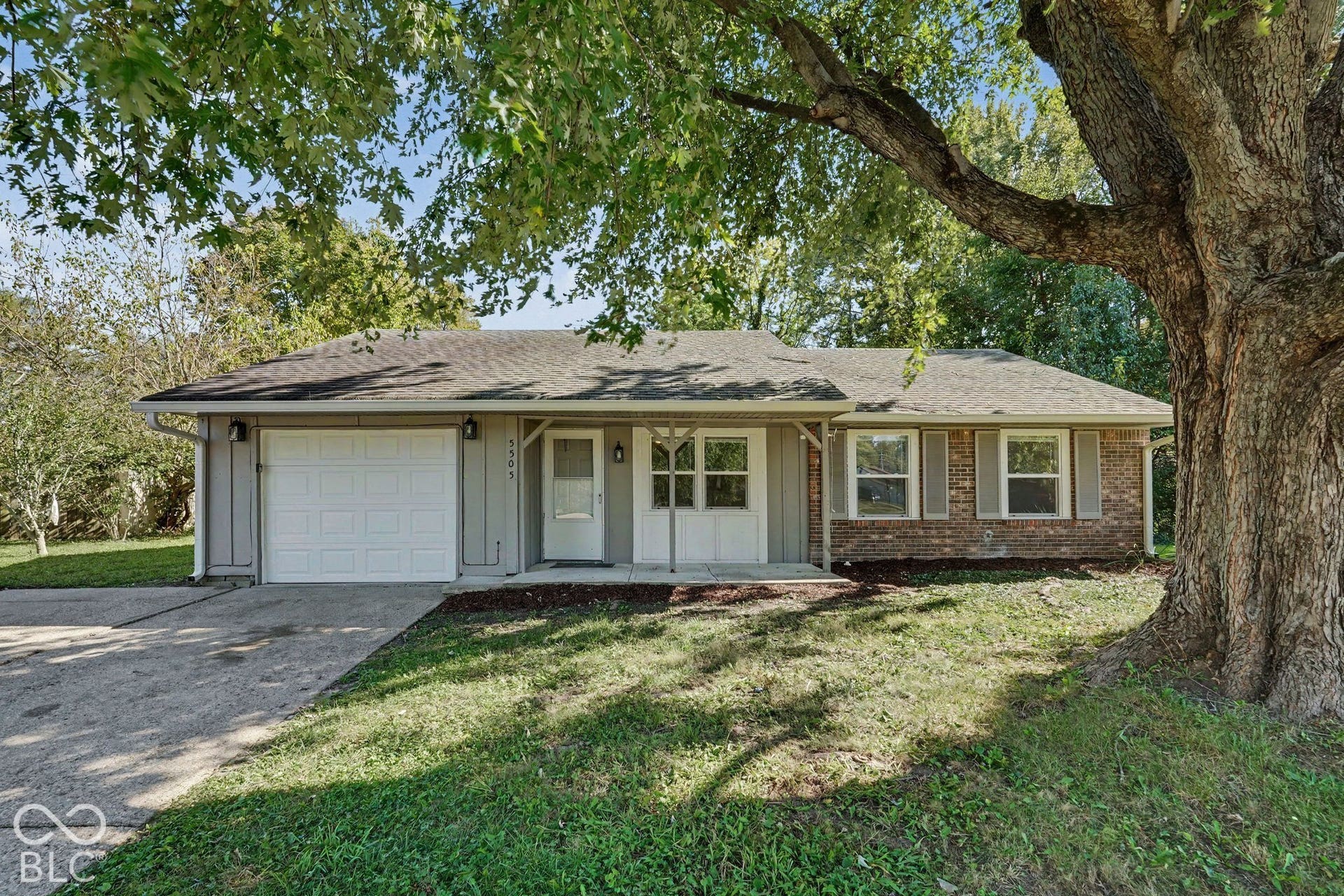 Ranch-style exterior with a partial brick facade, horizontal siding, and a covered entry