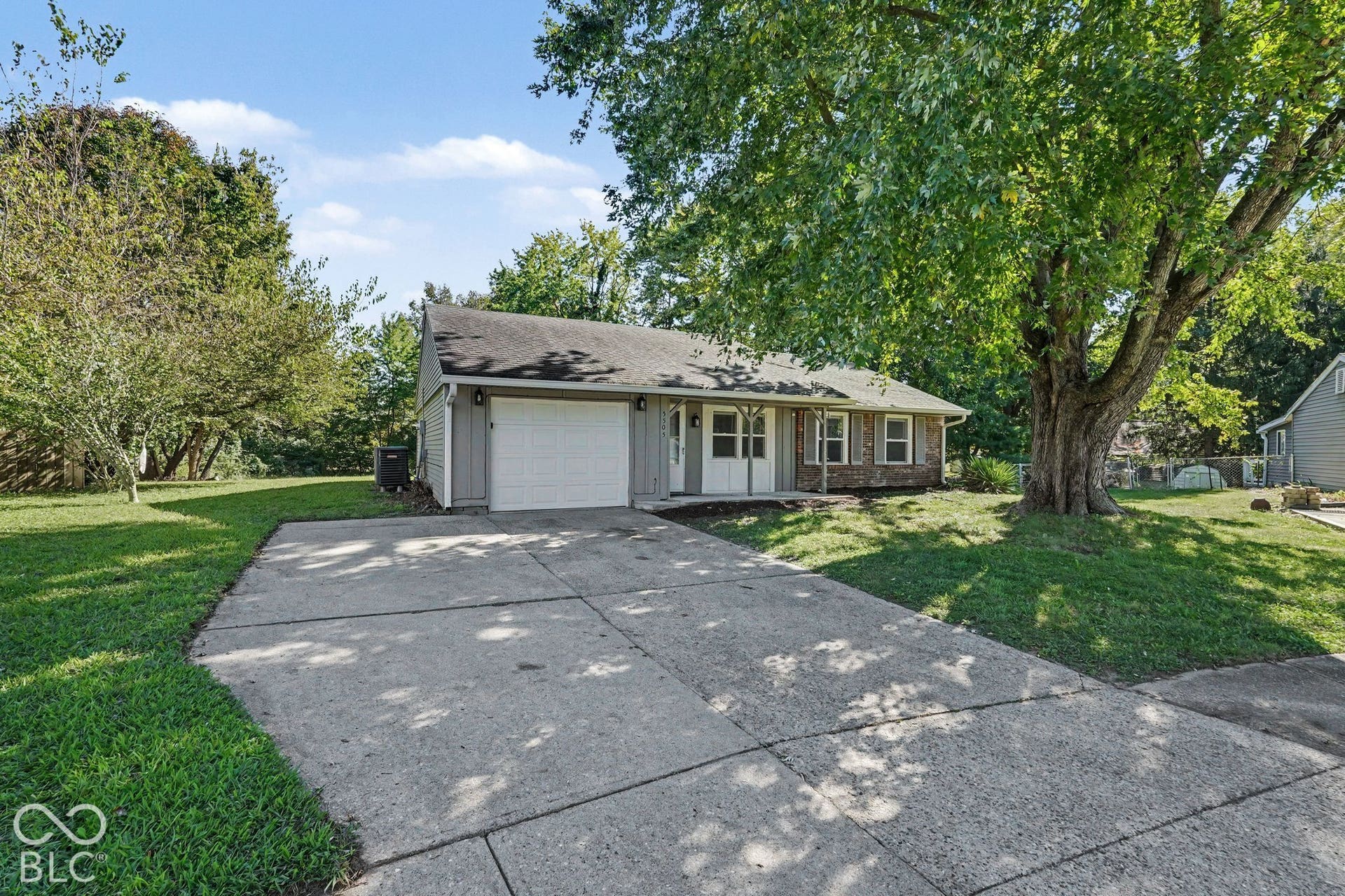 Single-story residence featuring a concrete driveway, attached garage, and a covered entry porch