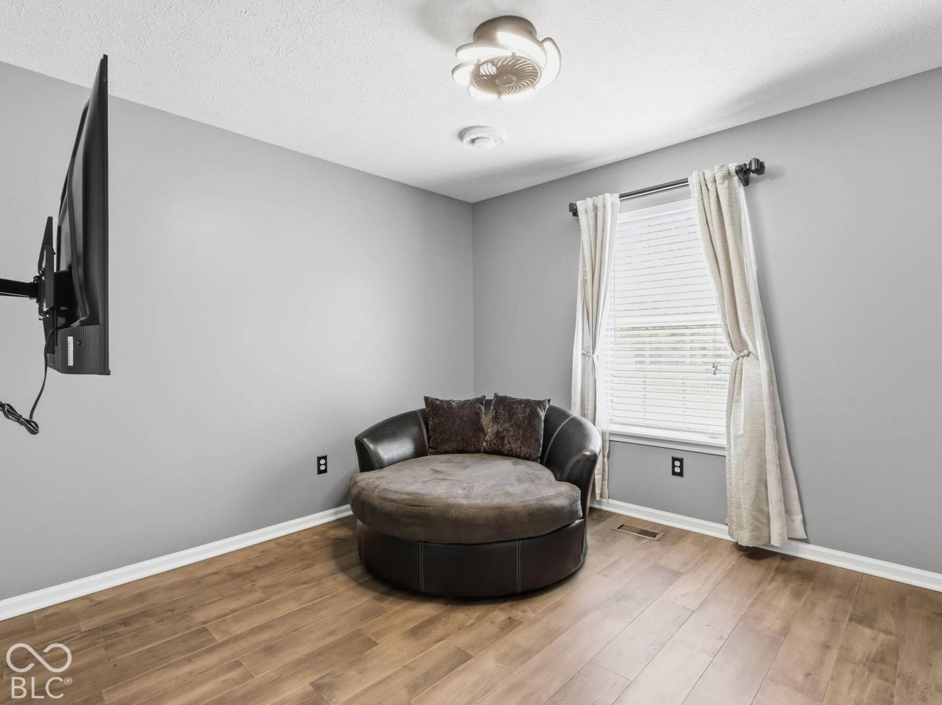 Bedroom #2 with mounted TV and large lounge chair that stays with home