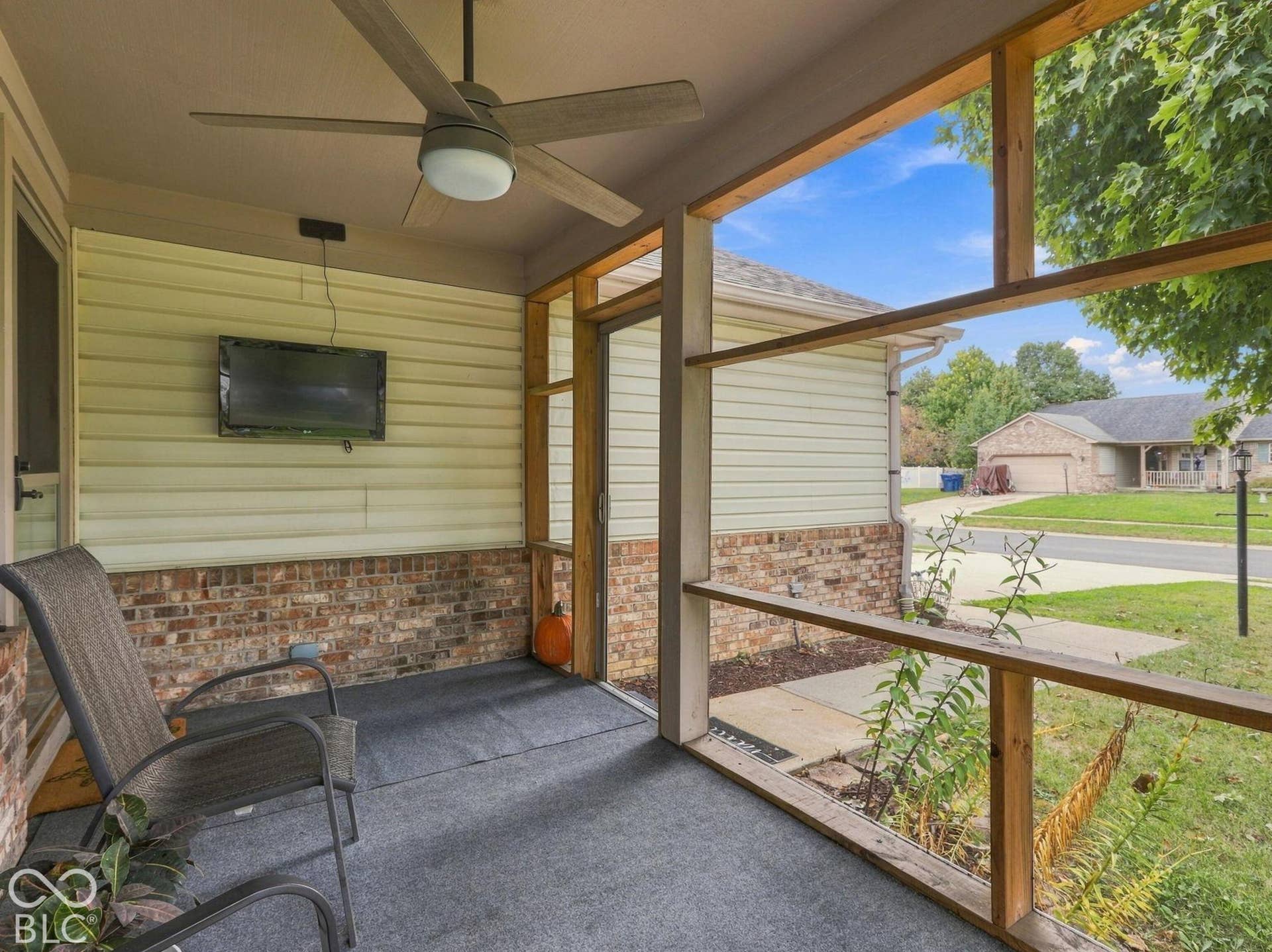 The screened in porch as a ceiling fan and a mounted television