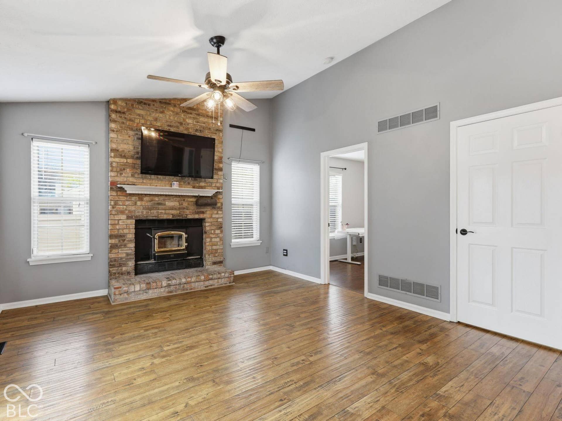Family room has lots of natural light, and high ceilings with a lighted ceiling fan