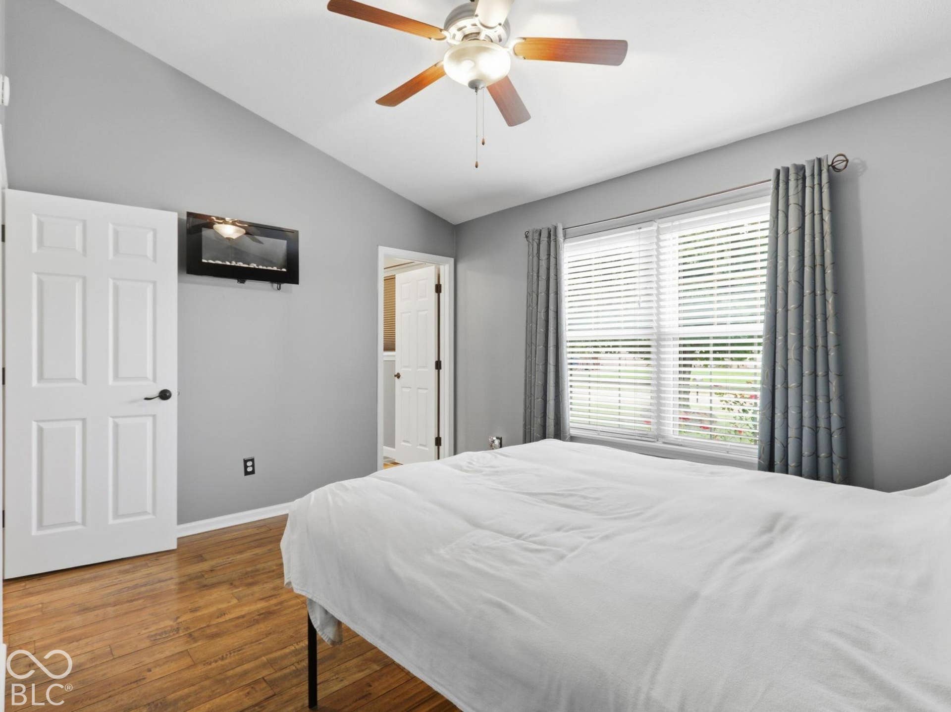 Primary bedroom has a wall mounted electric fireplace for warmth and ambiance