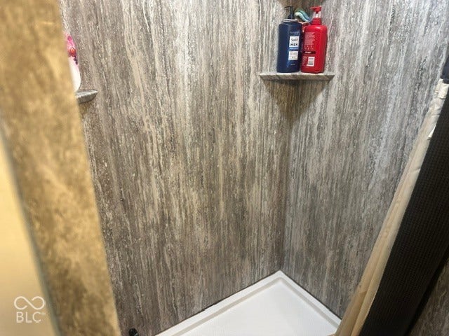 1832 Bauer, Indianapolis, IN 46218 Shower enclosure featuring stone-patterned wall surround and integrated corner shelving