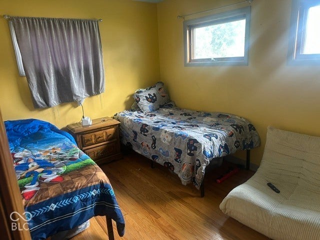 1832 Bauer, Indianapolis, IN 46218 Room featuring wood-finish flooring and multiple windows with neutral-toned trim