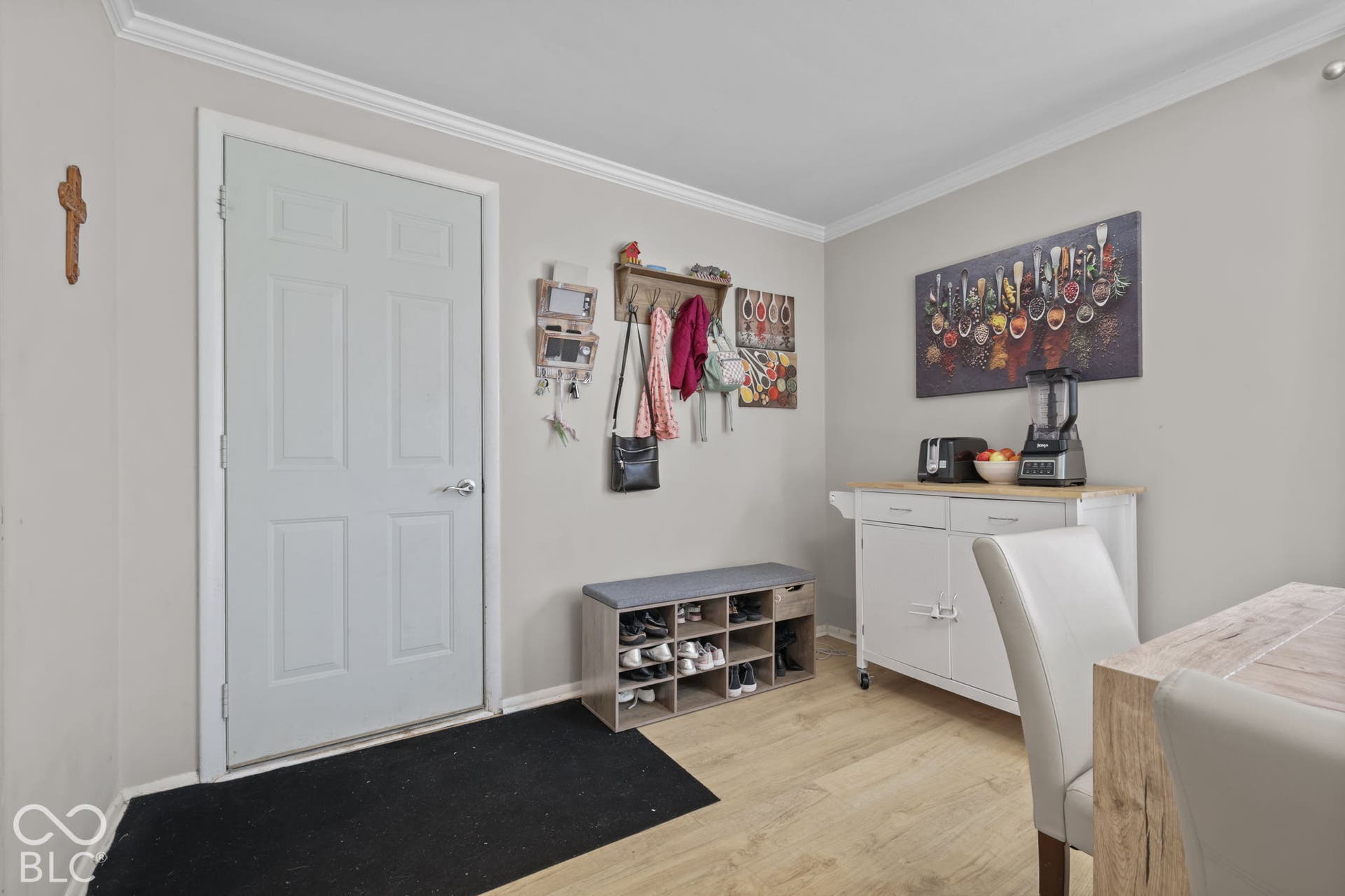 Neutral-toned interior space featuring crown molding and wood-finish flooring throughout