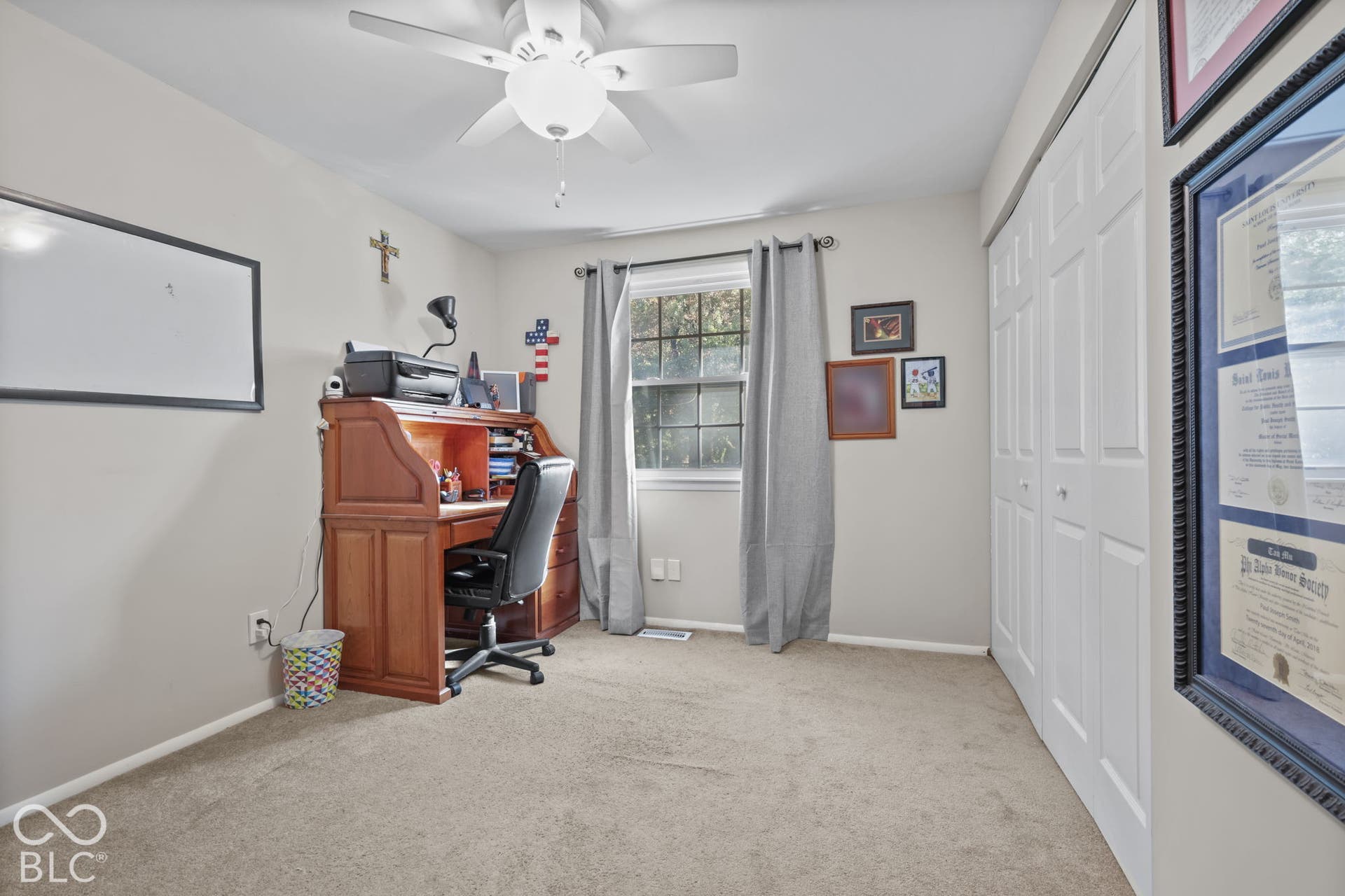 Room featuring neutral carpeting, multi-pane window, ceiling fan with integrated lighting, and closet with bifold doors