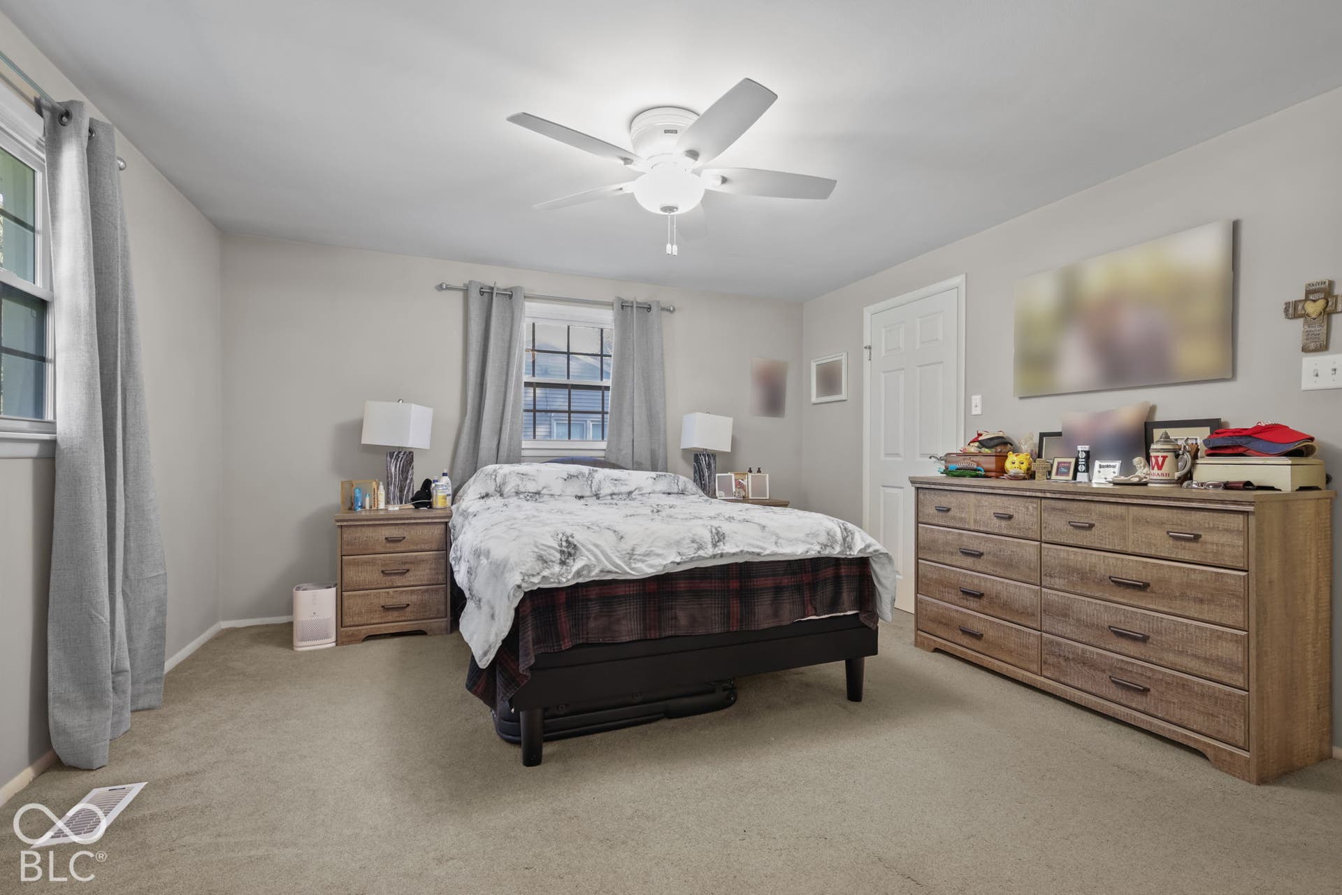 Bedroom featuring neutral wall paint, wall-to-wall carpeting, a multi-pane window, and a central ceiling fan with integrated lighting