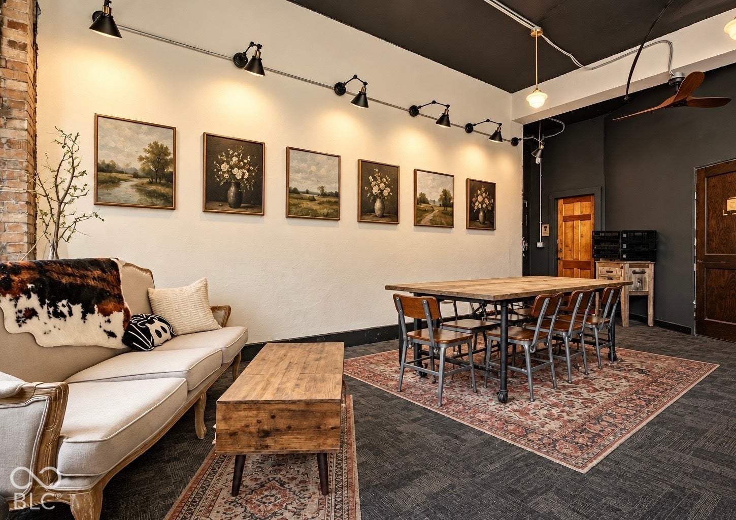 2602 Shelby Street, Indianapolis, IN 46203 Virtually Altered - Industrial-style interior featuring exposed brick columns, high ceilings with exposed electrical conduit lighting, a wooden ceiling fan, and solid wood interior door with hardware