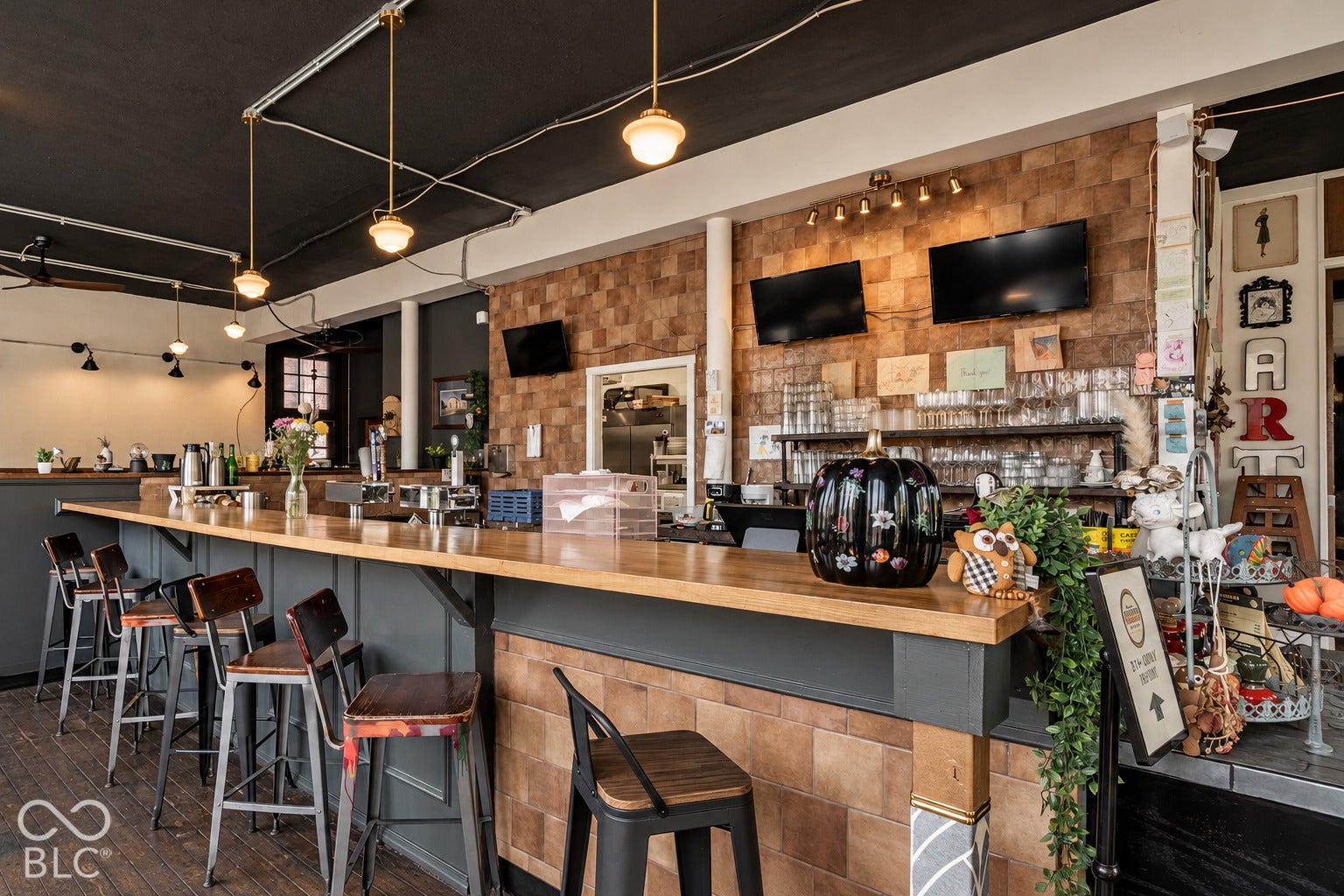 2602 Shelby Street, Indianapolis, IN 46203 Virtually Altered - Built-in bar featuring a wood-topped counter, textured masonry backsplash, pendant globe lighting, track lighting, and dark-toned cabinetry