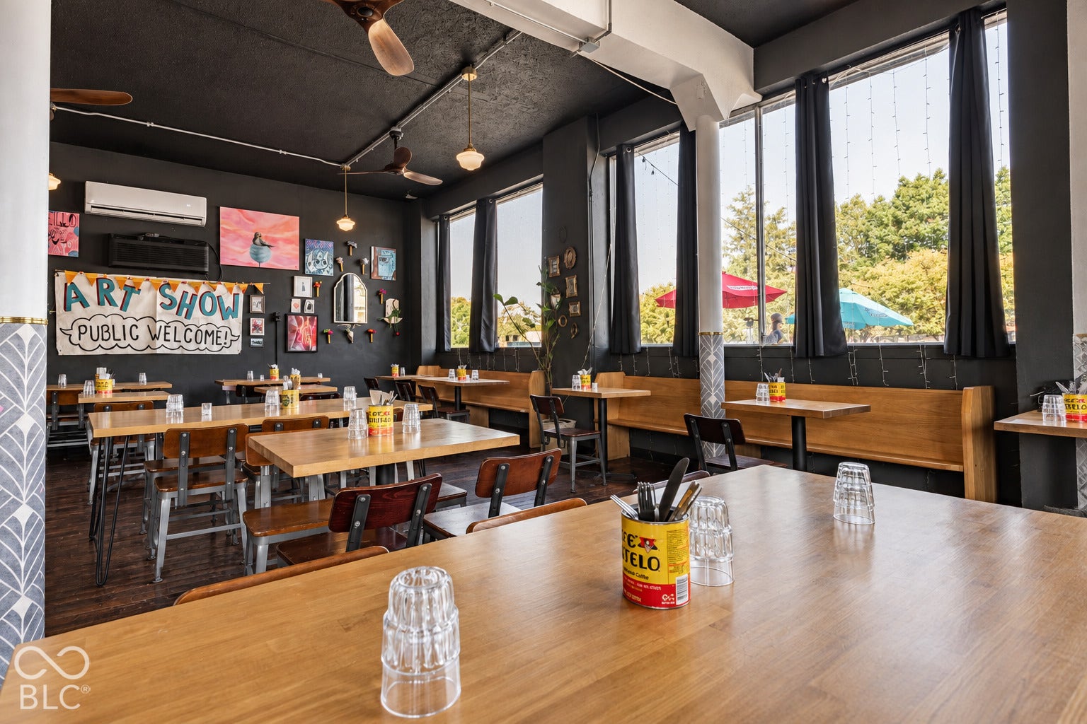 2602 Shelby Street, Indianapolis, IN 46203 Virtually Altered - Open-concept interior space featuring floor-to-ceiling windows, built-in wooden bench seating, dark-toned exposed ceiling, and wood-finish flooring