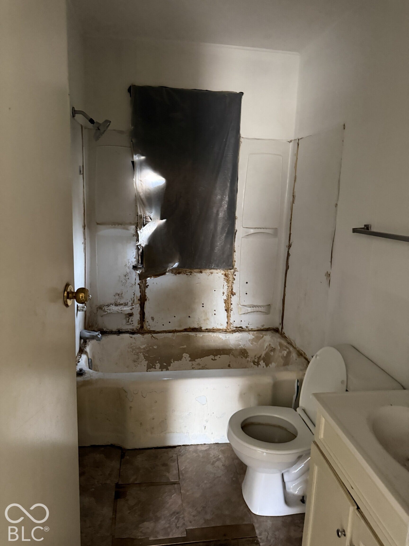 3351 N Grant Avenue, Indianapolis, IN 46218 Bathroom featuring a built-in bathtub, a showerhead, a toilet, and a vanity cabinet