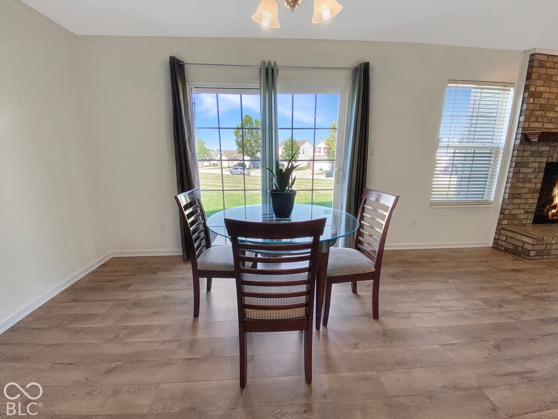 4726 Eva Court, Indianapolis, IN 46227 Sliding glass doors with grid detailing, wood-finish flooring, and floor-to-ceiling brick masonry fireplace