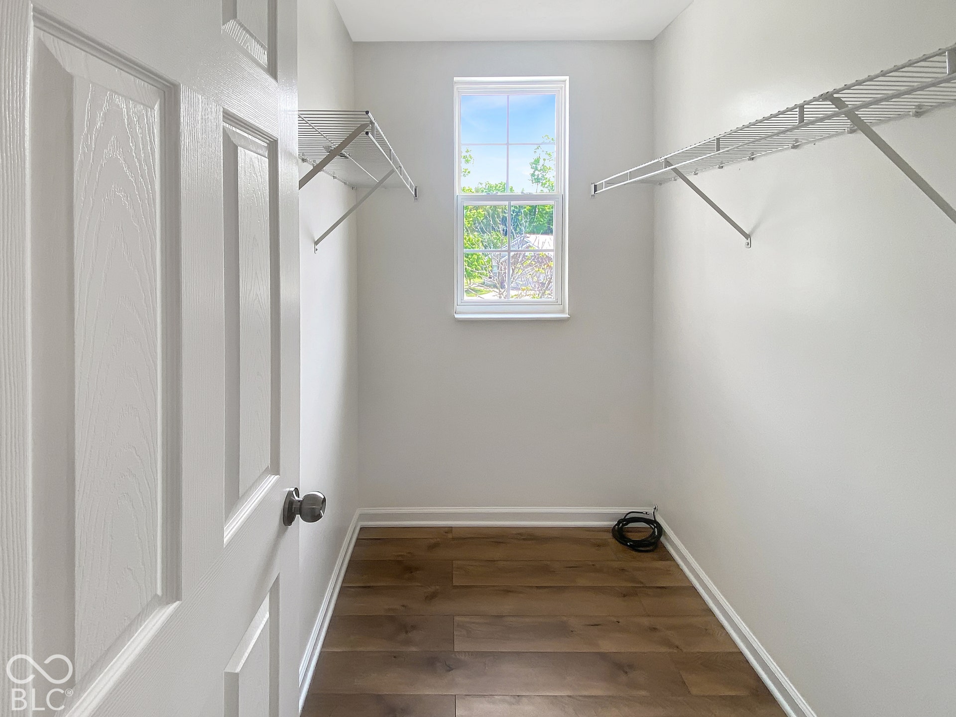 4726 Eva Court, Indianapolis, IN 46227 Storage area featuring wood-finish flooring, a single-hung window, and dual white wire shelving units