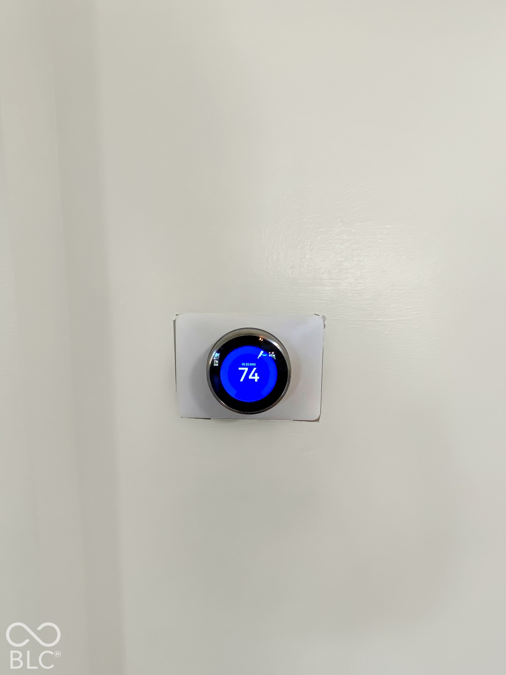 4726 Eva Court, Indianapolis, IN 46227 Programmable smart thermostat with a digital circular display and metallic finish mounted on a neutral-toned wall