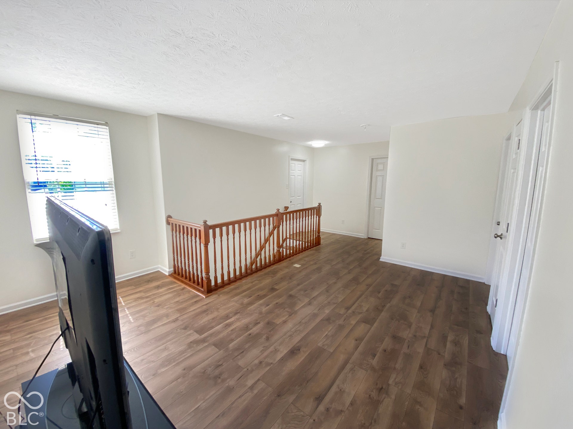 4726 Eva Court, Indianapolis, IN 46227 Wood-finish flooring, white walls, and a wooden handrail with vertical balusters