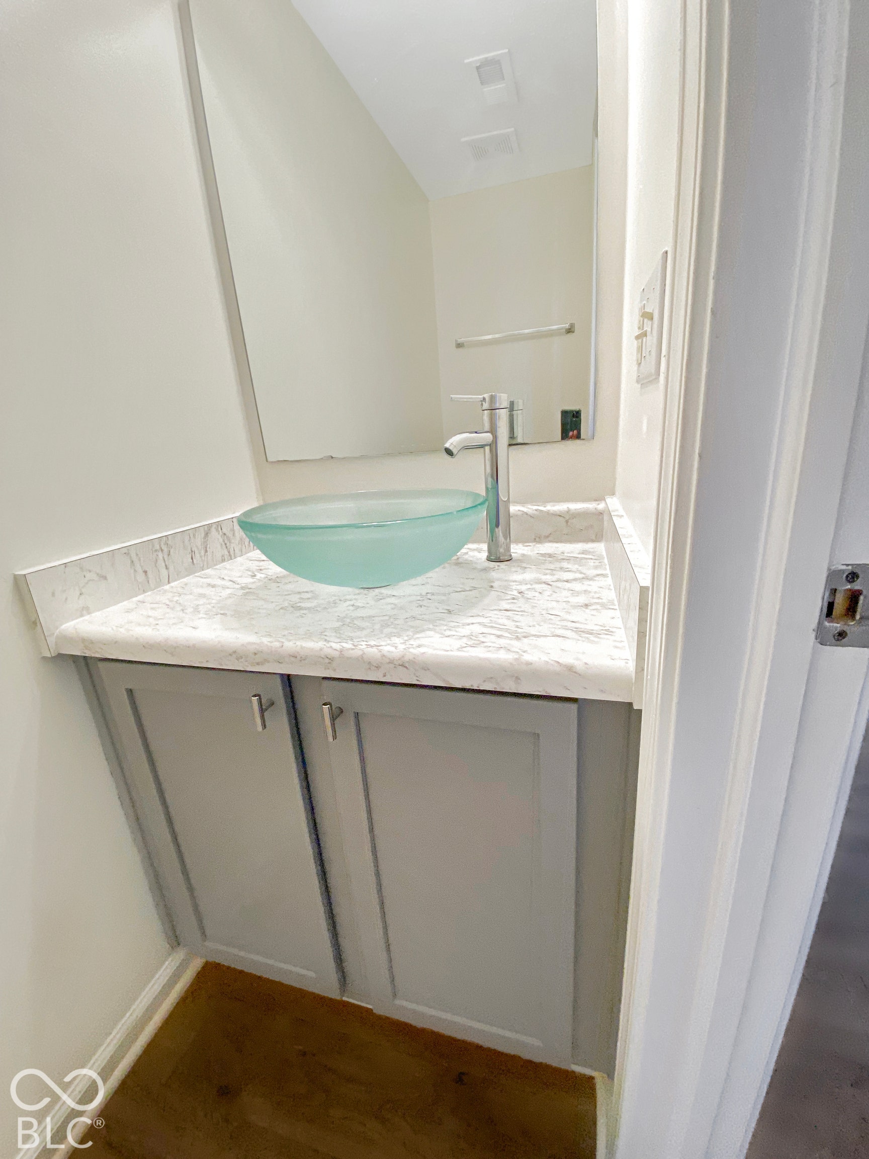 4726 Eva Court, Indianapolis, IN 46227 Vanity featuring grey shaker-style cabinetry, patterned stone-surface countertop, translucent glass vessel sink, chrome finish faucet, and wall-mounted mirror