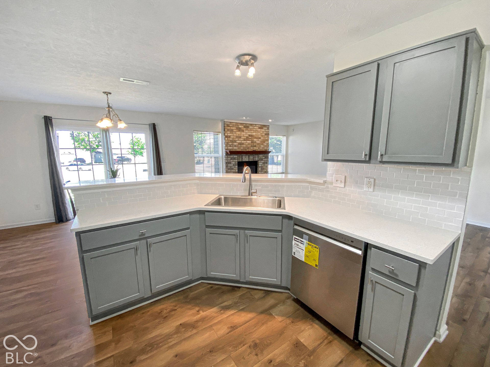 4726 Eva Court, Indianapolis, IN 46227 Kitchen featuring grey shaker-style cabinetry, white quartz countertops, white subway tile backsplash, stainless steel dishwasher, and wood-finish flooring