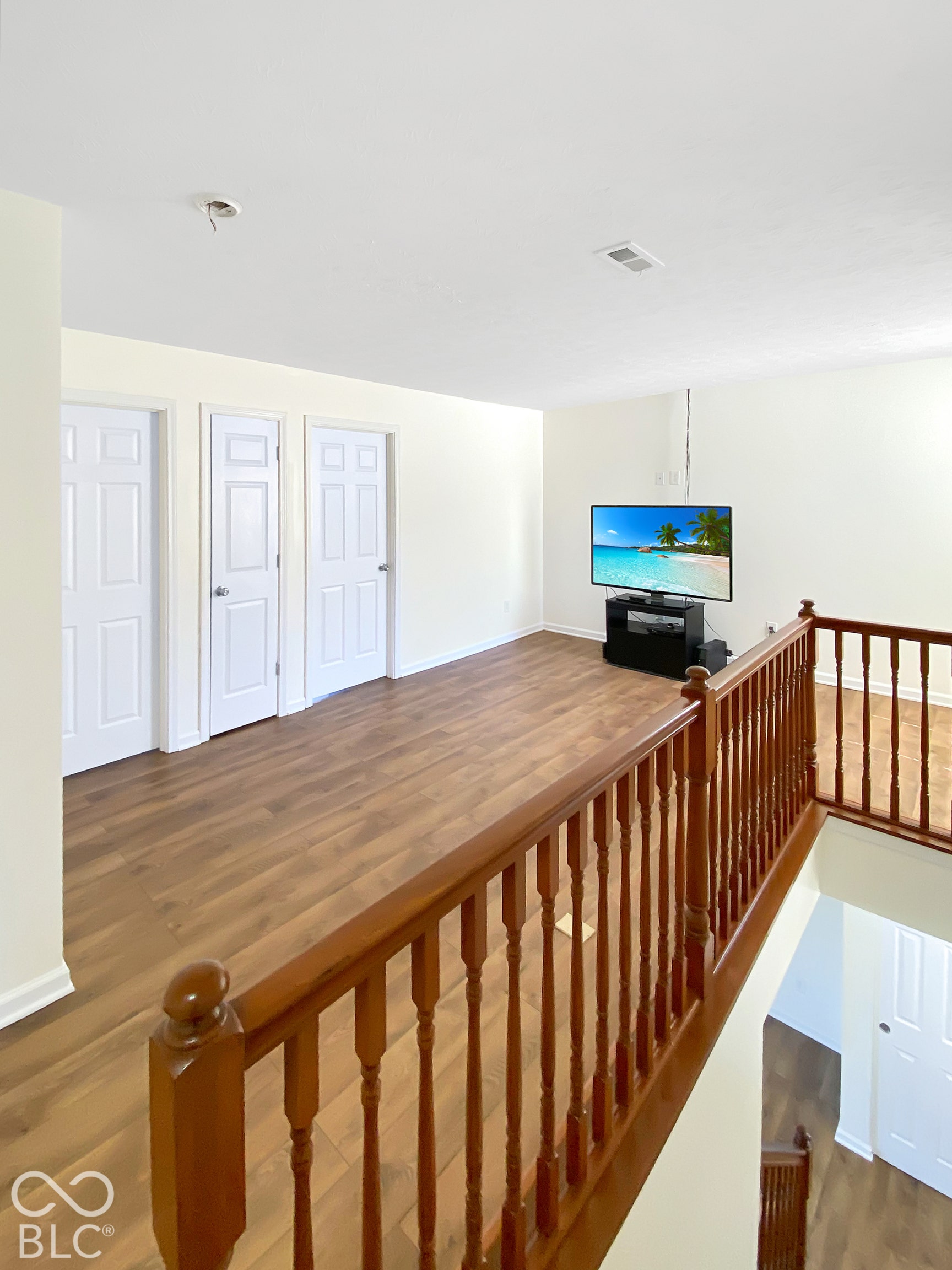 4726 Eva Court, Indianapolis, IN 46227 Wood-finish flooring, three interior six-panel doors, and a stained wood baluster railing