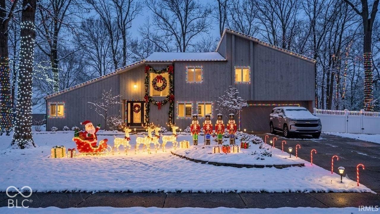 Virtually Altered - Two-story contemporary exterior with vertical wood siding, multi-level roofline, attached garage, and paved driveway, situated on a lot with mature trees and perimeter vinyl fencing