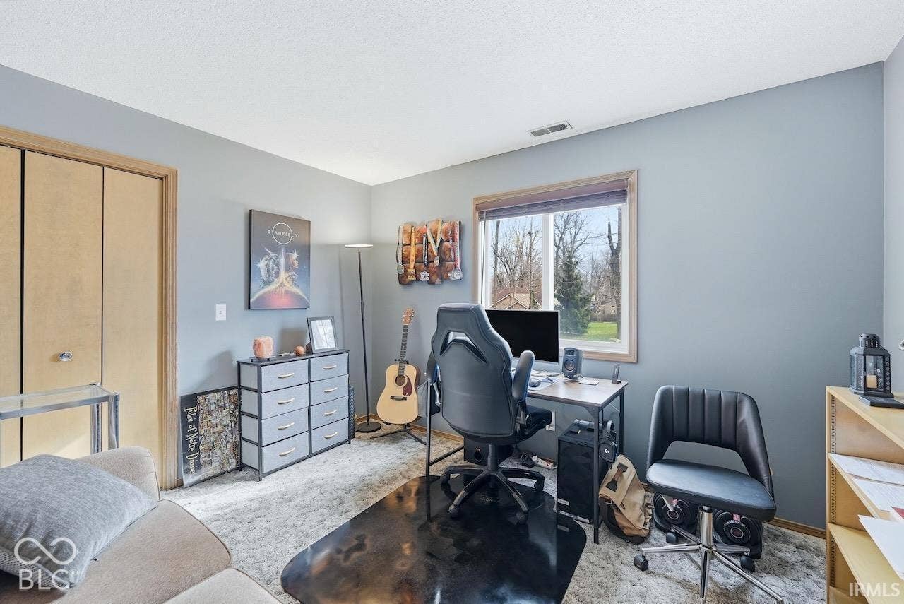Interior room featuring neutral wall paint, carpeted flooring, and a single-pane window with wood-finish trim and integrated roller shade