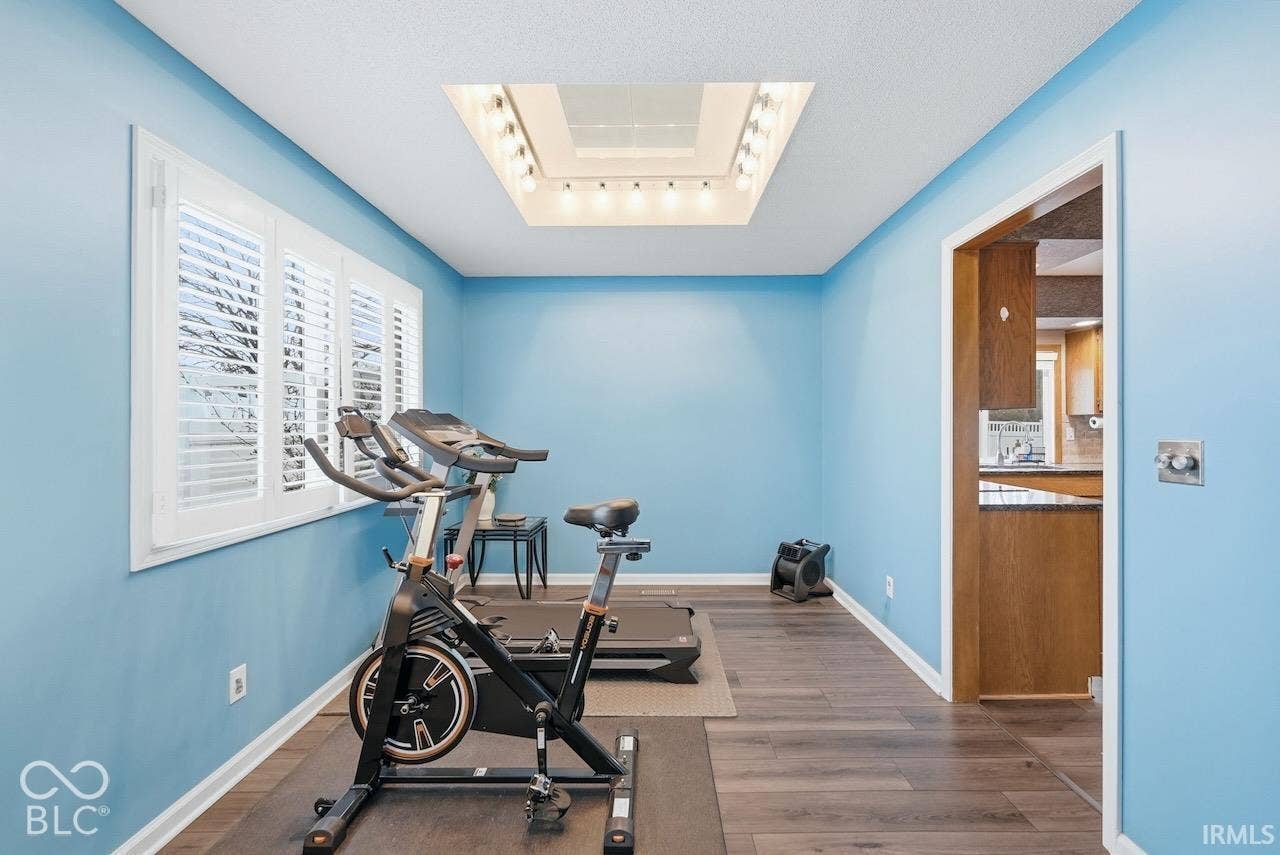 Recessed ceiling lighting feature, wood-finish flooring, and white plantation-style shutters