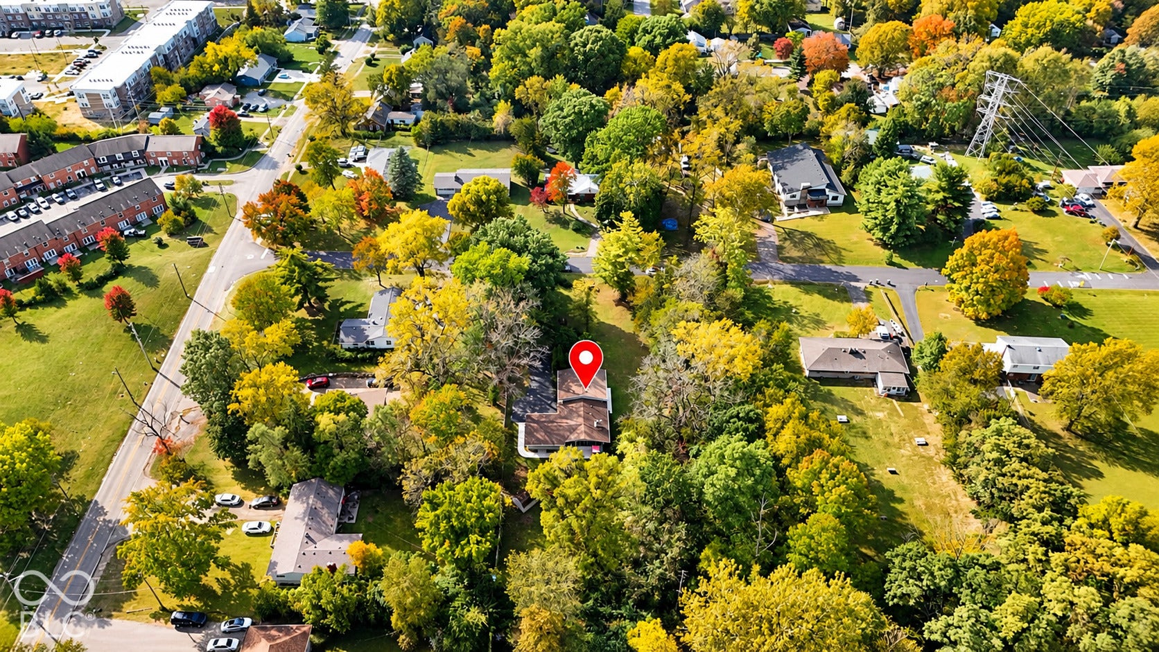 4225 Westbourne Drive, Indianapolis, IN 46205 Aerial perspective of a multi-level structure featuring a hipped roof, asphalt shingles, and extensive mature tree canopy coverage