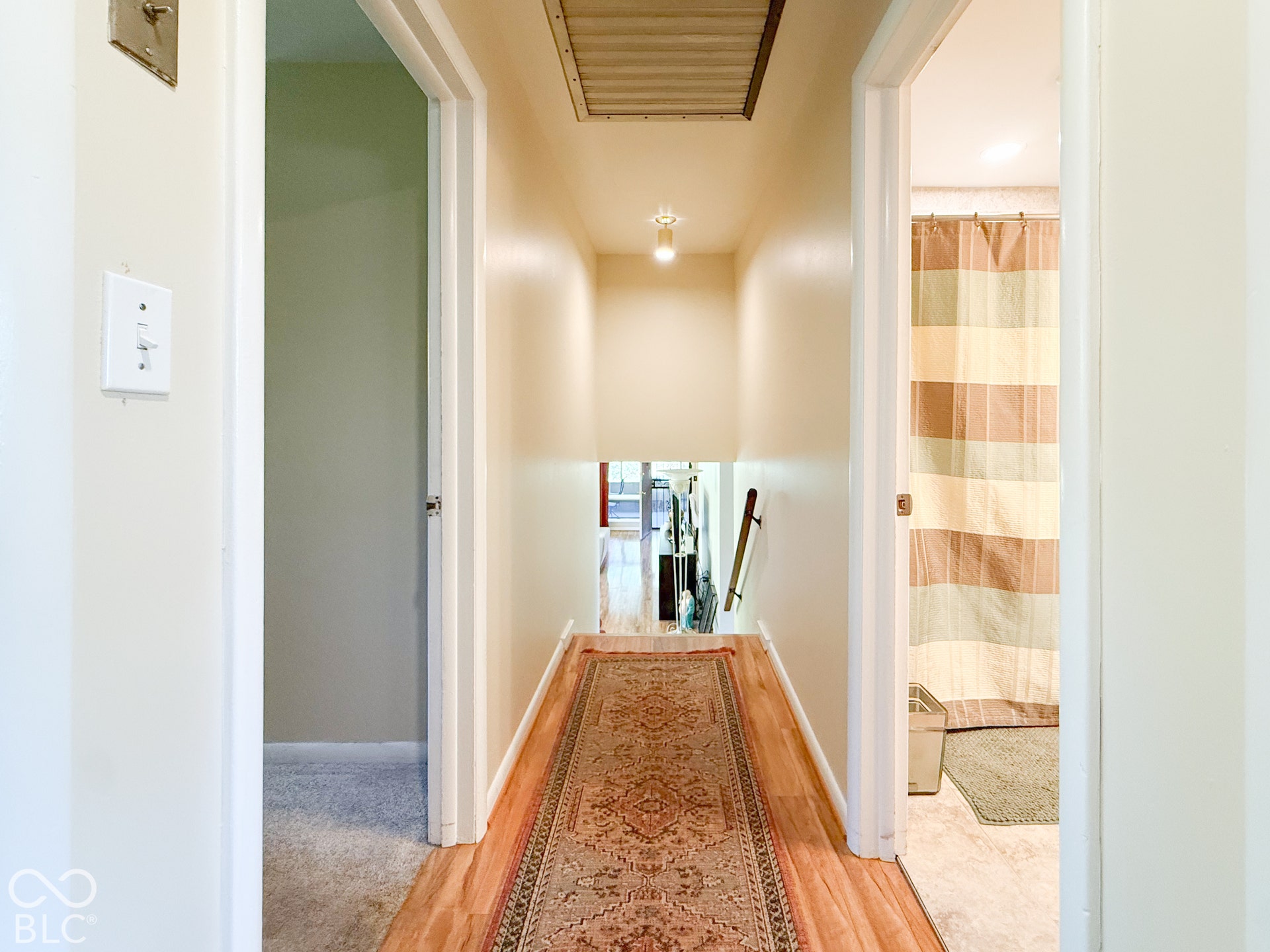4225 Westbourne Drive, Indianapolis, IN 46205 Hallway featuring wood-finish flooring, neutral wall paint, and integrated ceiling lighting