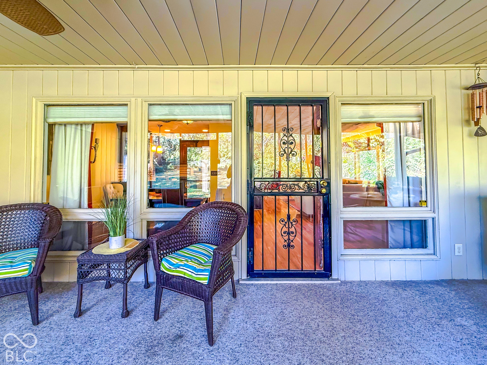4225 Westbourne Drive, Indianapolis, IN 46205 Covered porch featuring a concrete floor, horizontal siding, large multi-pane windows, and a decorative wrought iron security screen door