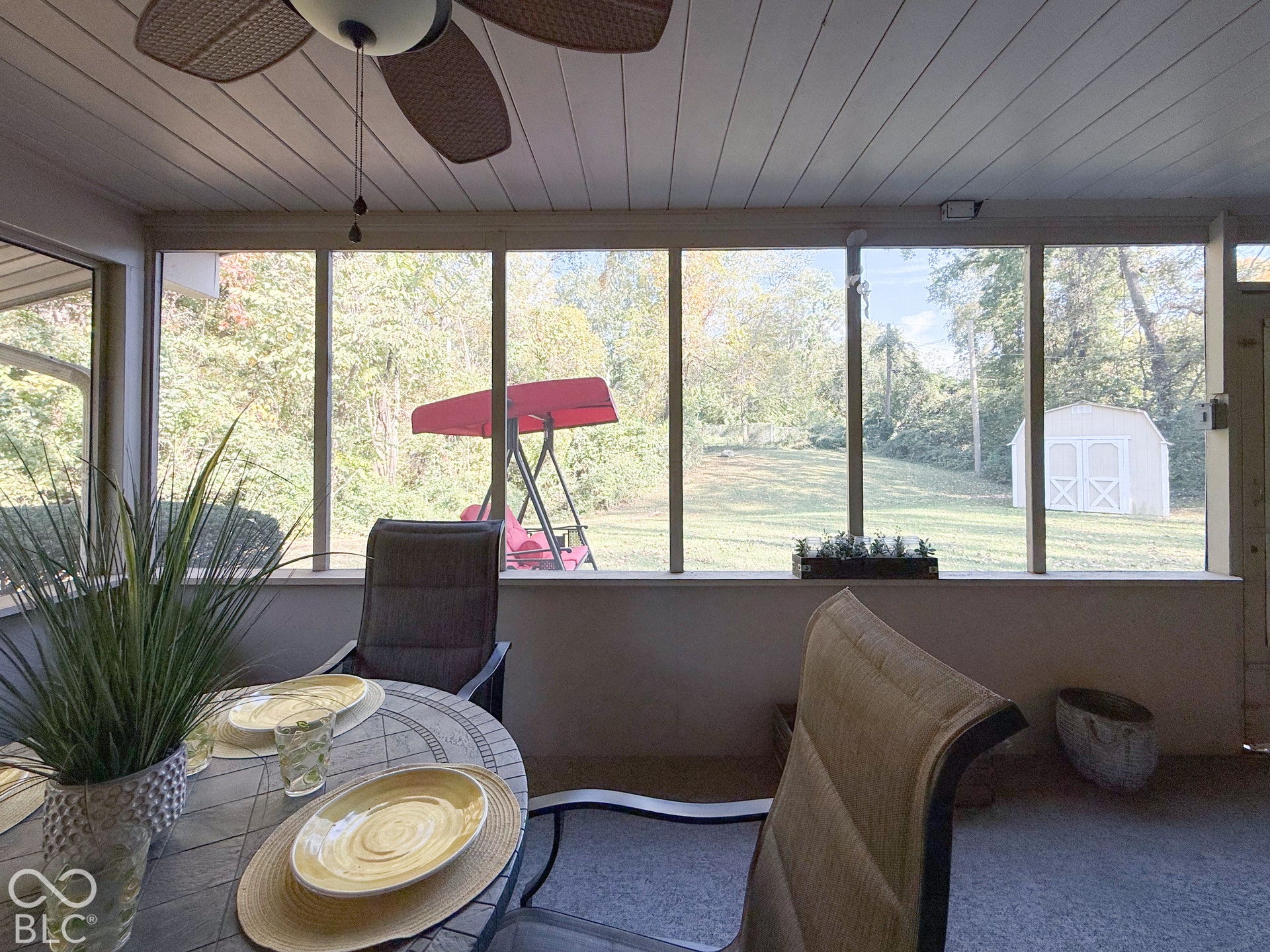 4225 Westbourne Drive, Indianapolis, IN 46205 Screened-in porch featuring a beadboard ceiling, ceiling fan, and full-length window screens overlooking a fenced-in backyard