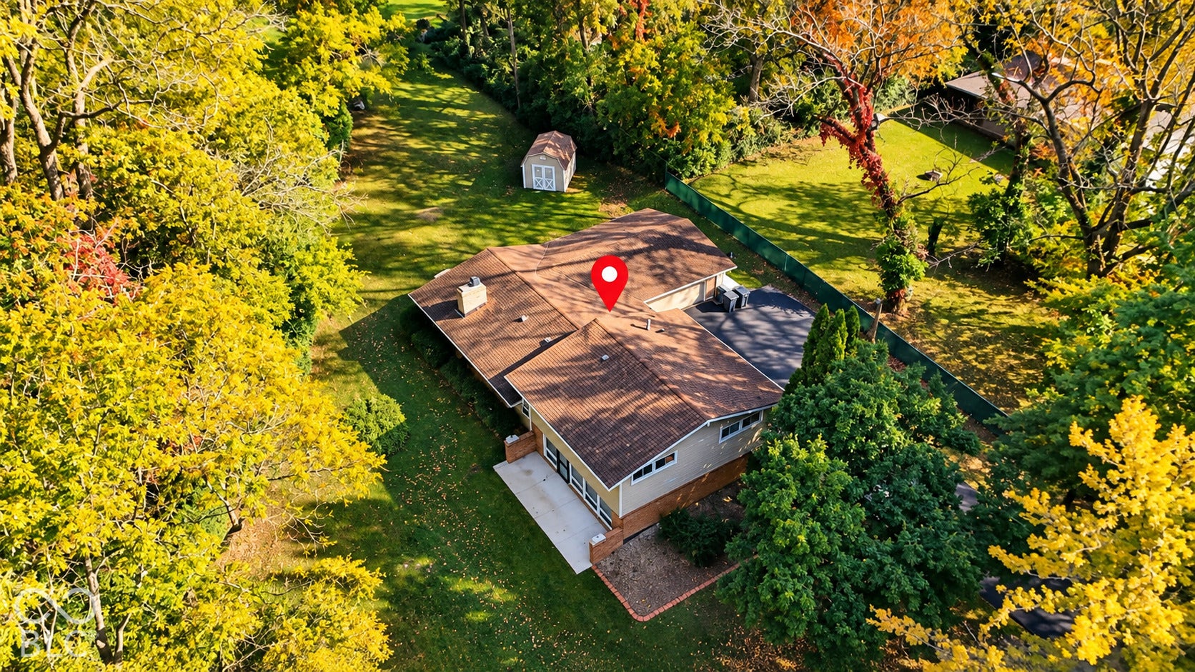 4225 Westbourne Drive, Indianapolis, IN 46205 Expansive lot featuring mature trees, a detached storage shed, a paved patio, and a shingled roof