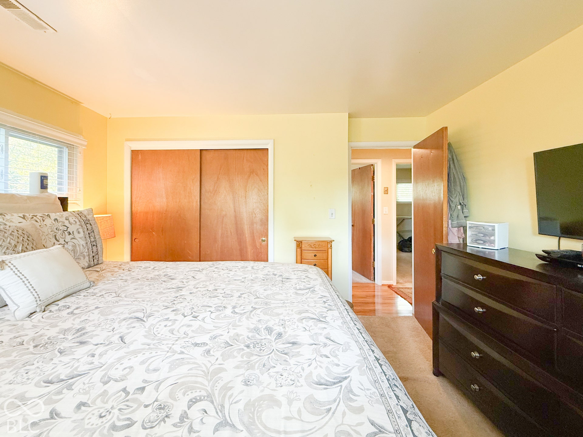 4225 Westbourne Drive, Indianapolis, IN 46205 Room featuring dual wood-finish sliding closet doors, neutral wall paint, and carpeted flooring