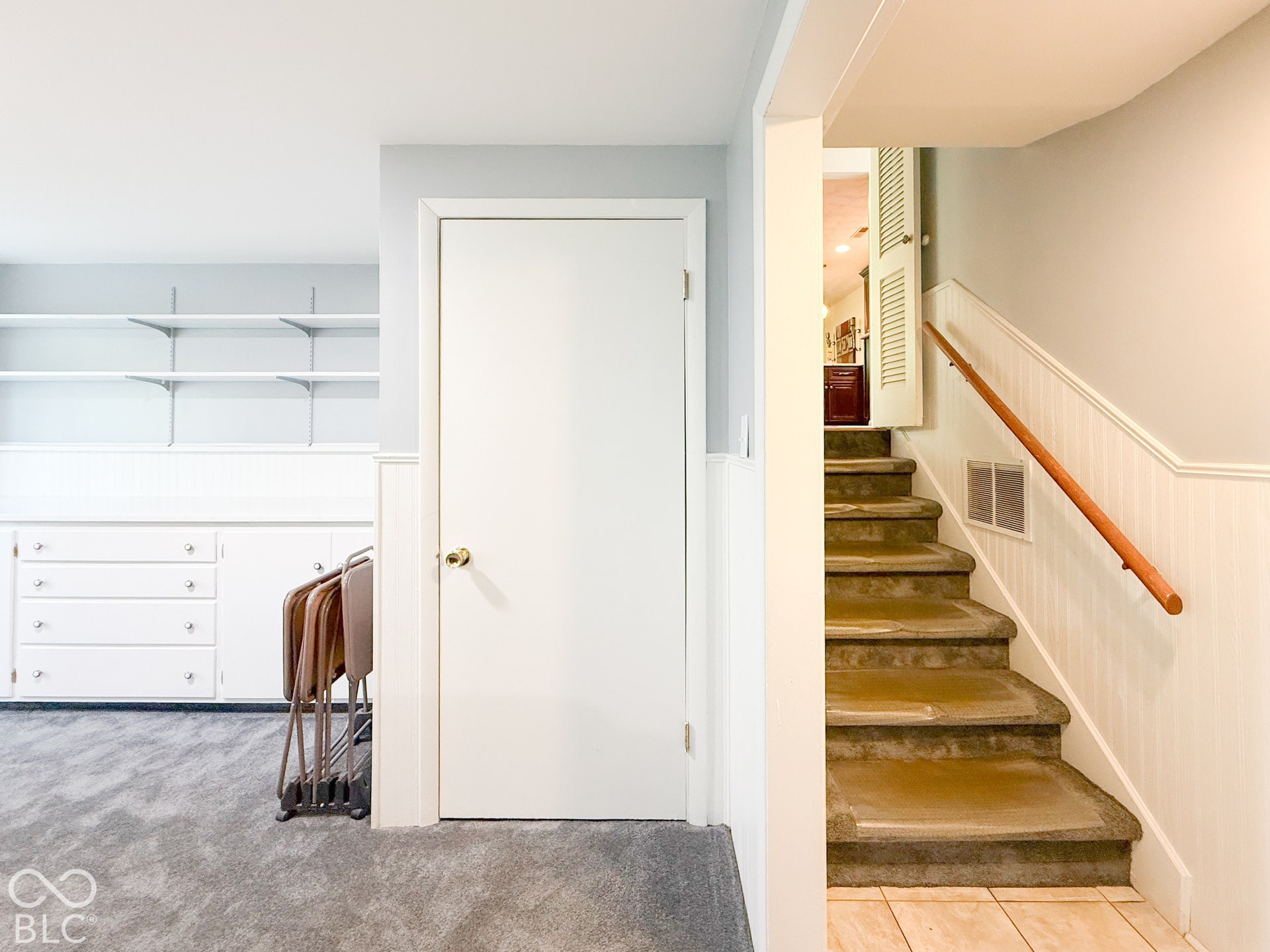 4225 Westbourne Drive, Indianapolis, IN 46205 Built-in cabinetry with integrated shelving and drawer storage, wainscoting detail, and staircase featuring a wood handrail