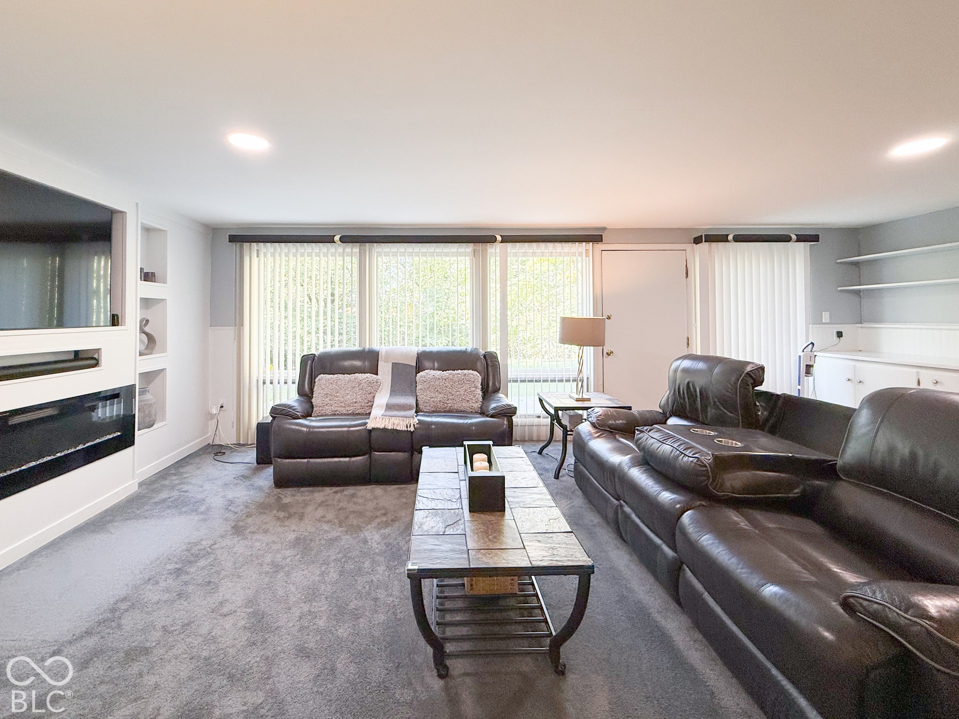 4225 Westbourne Drive, Indianapolis, IN 46205 Wall-mounted electric fireplace, built-in shelving, recessed lighting, and wall-to-wall carpeting