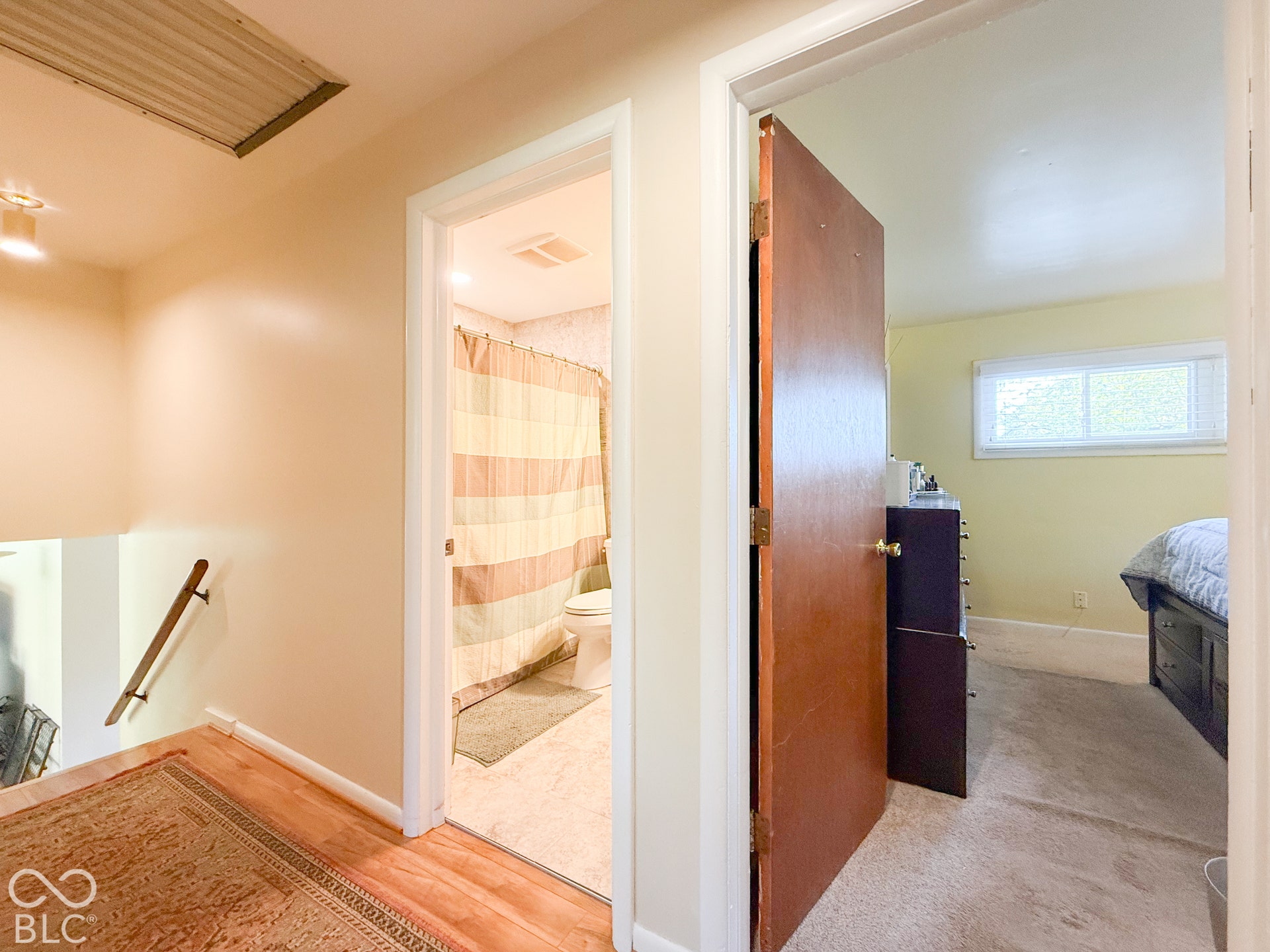 4225 Westbourne Drive, Indianapolis, IN 46205 Hallway featuring wood-finish flooring, a wooden handrail, and interior doors