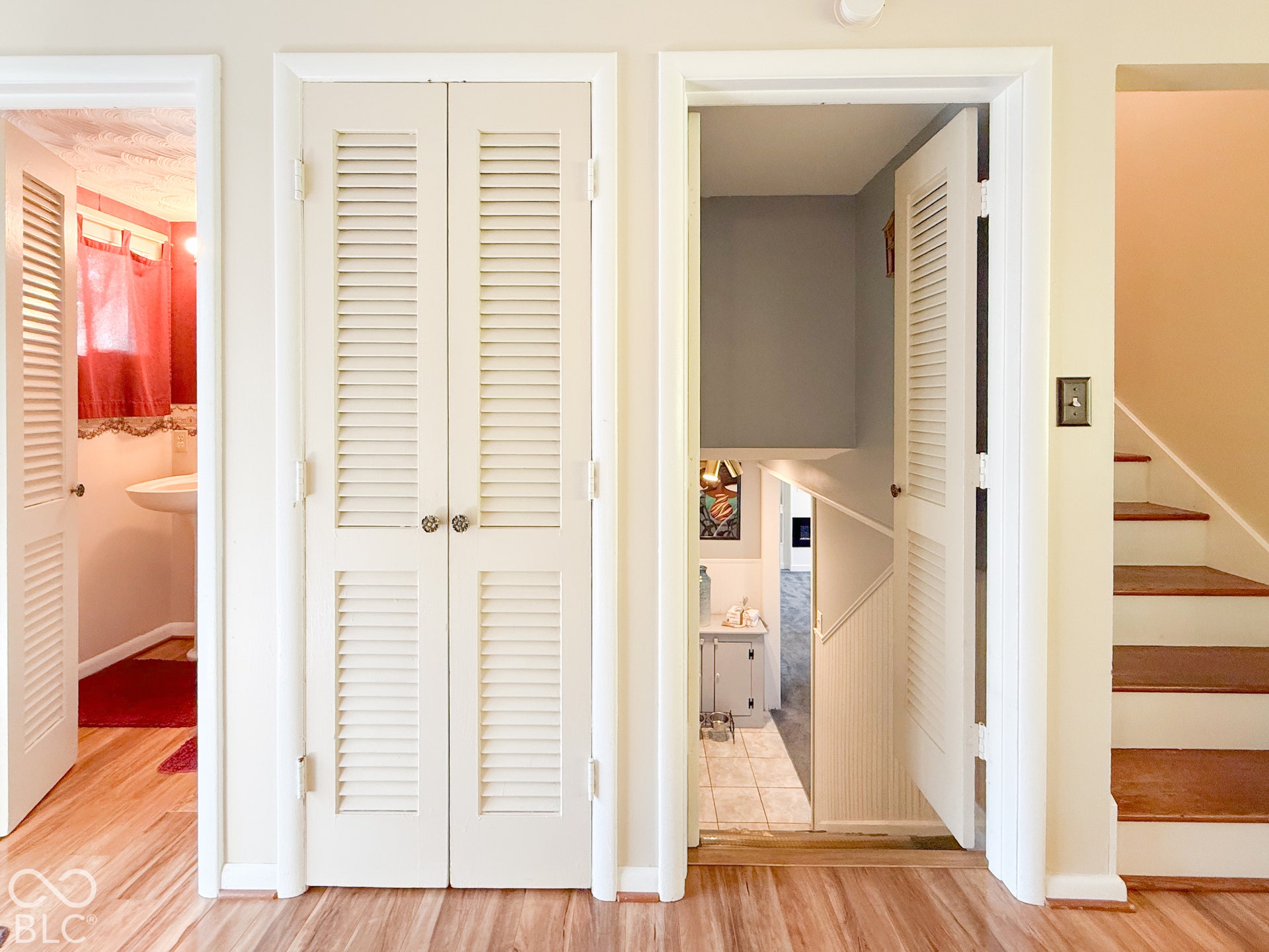 4225 Westbourne Drive, Indianapolis, IN 46205 Double bifold louvered closet doors, wood-finish flooring, and a staircase featuring wood-finish treads