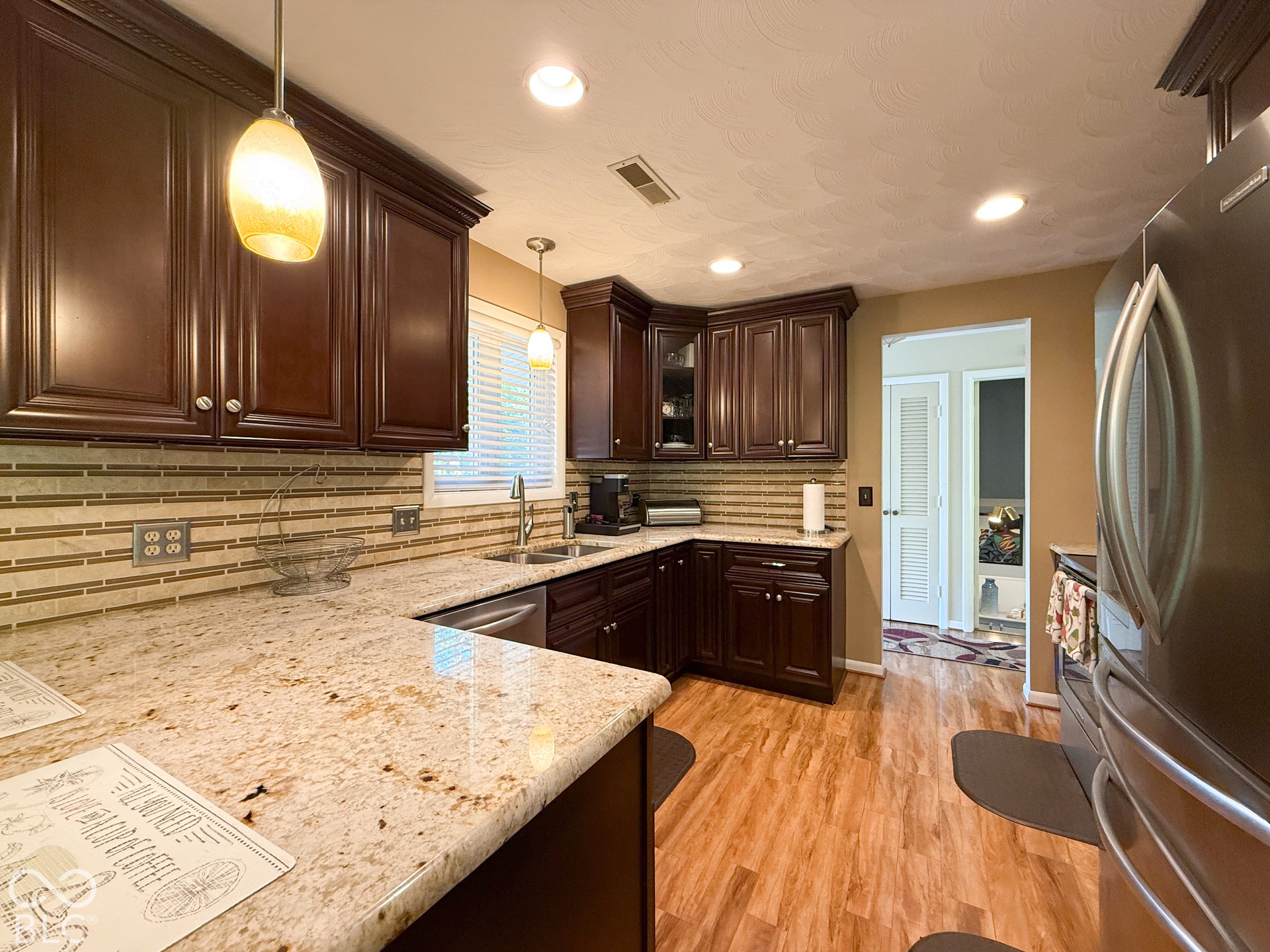 4225 Westbourne Drive, Indianapolis, IN 46205 Kitchen featuring dark cabinetry, stone countertops, horizontal tile backsplash, stainless steel appliances, and wood-finish flooring