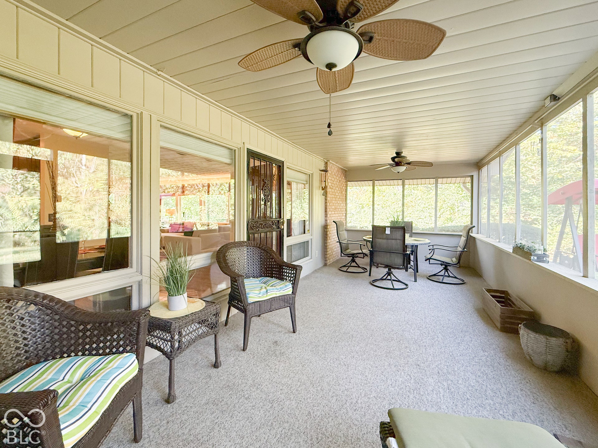 4225 Westbourne Drive, Indianapolis, IN 46205 Enclosed sunroom featuring expansive windows, two ceiling fans, and a metal security screen door