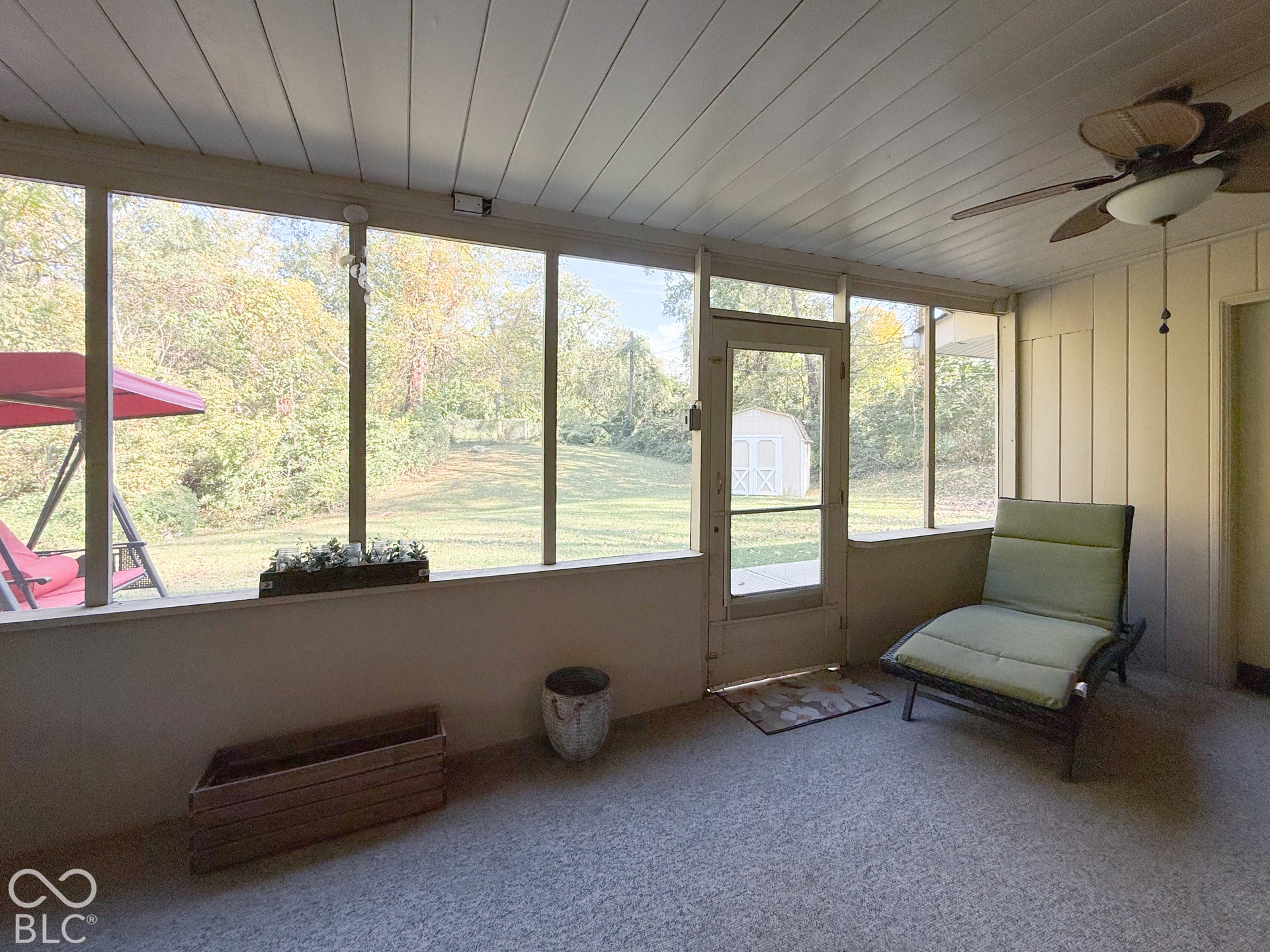 4225 Westbourne Drive, Indianapolis, IN 46205 Screened-in porch featuring a tongue-and-groove ceiling, ceiling fan with light kit, textured flooring, and expansive window screening
